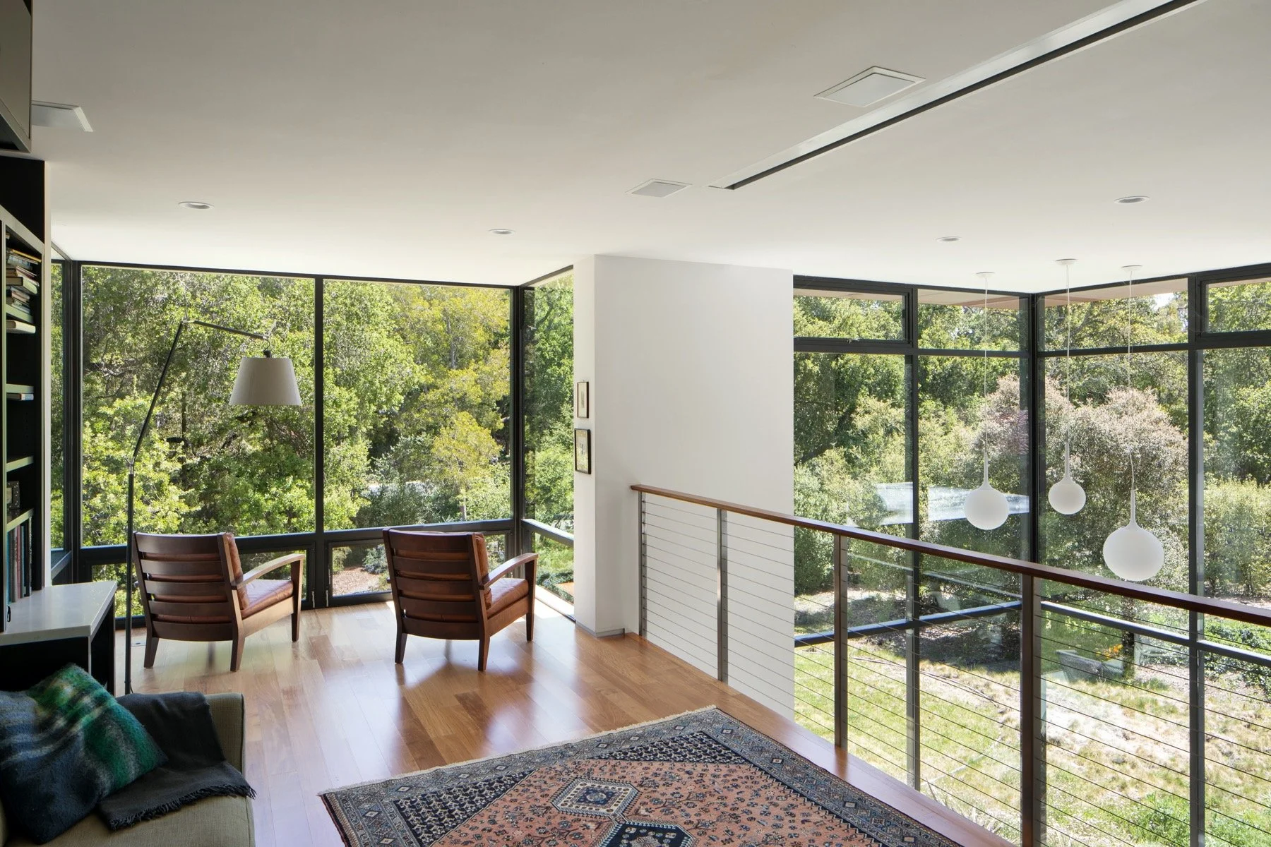  A lofted library and siting area above the dining room seems to float because of the double height windows. 