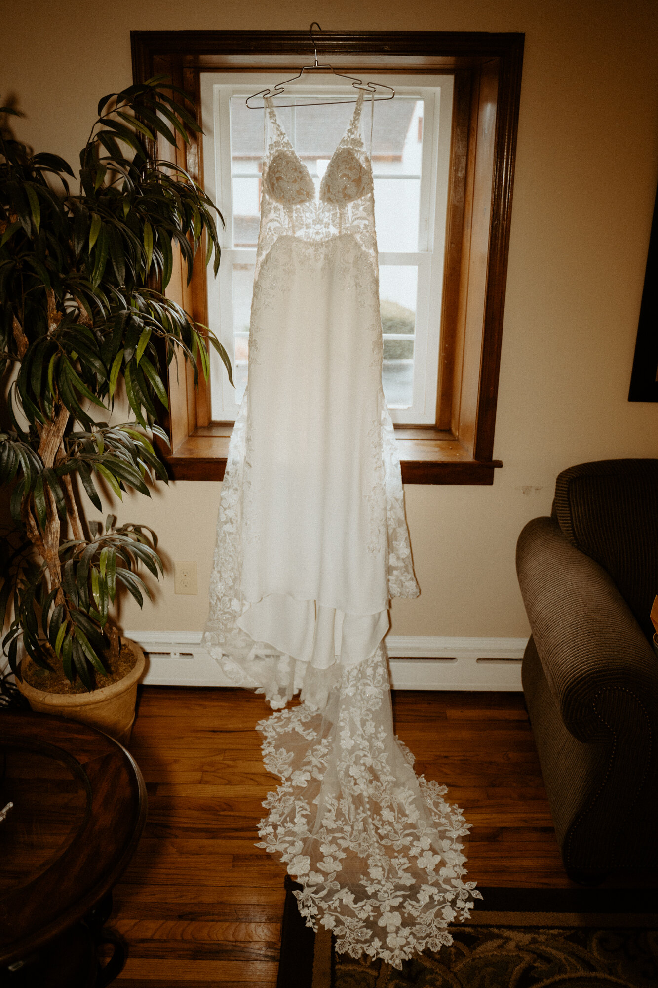 wedding dress hanging by a window