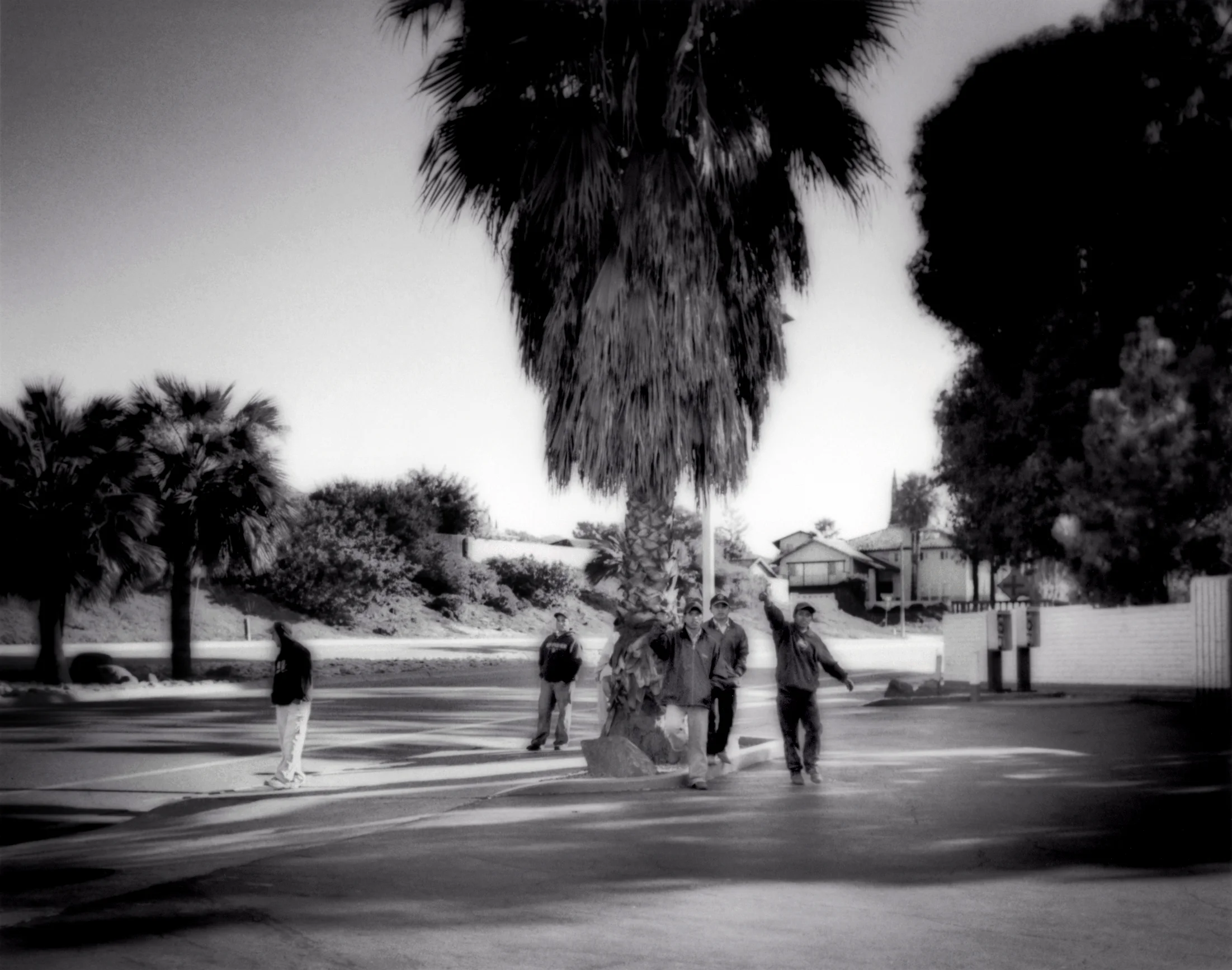 Migrants from Southern Mexico or Central America signal a desire for manual work while they wait in front of a petrol station in Rancho Bernardo, California, USA in 2006. Once successful in crossing into the United States, many migrants occupy street corners where motorists will stop and offered them day work in the garden or their homes. These migrants are in San Diego County, California. 