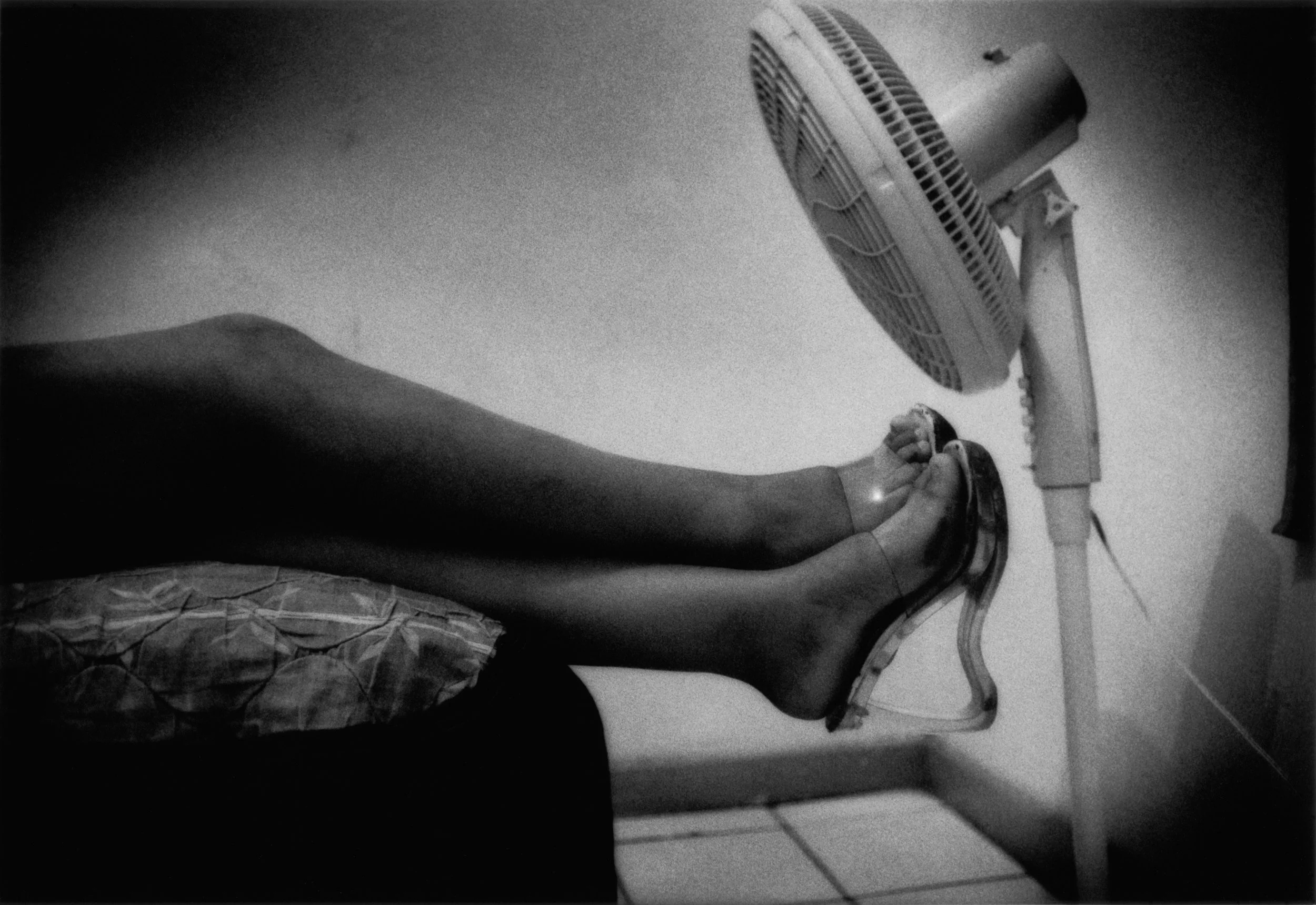 Erica, a 17 year old Paradita from Tijuana, stretches out her legs on bed in cheap hotel she uses to conduct sex business in the Zona Norte, Tijuana, Mexico. 2007