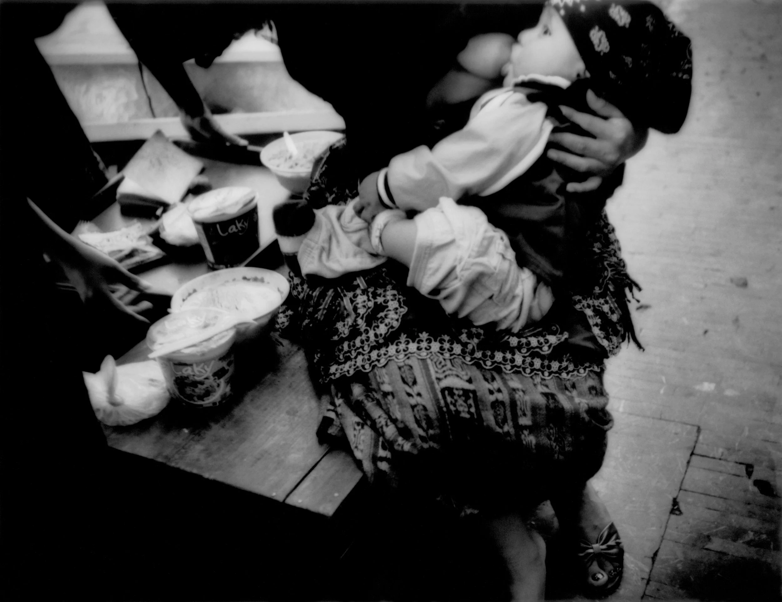 Mother breasts feeds child while tending her sidewalk stall in Guatemala City. According to the World Bank (2007), the average Guatemalan earns US$2,400 per year, which puts pressure on parents to feed and care for their children. 2008