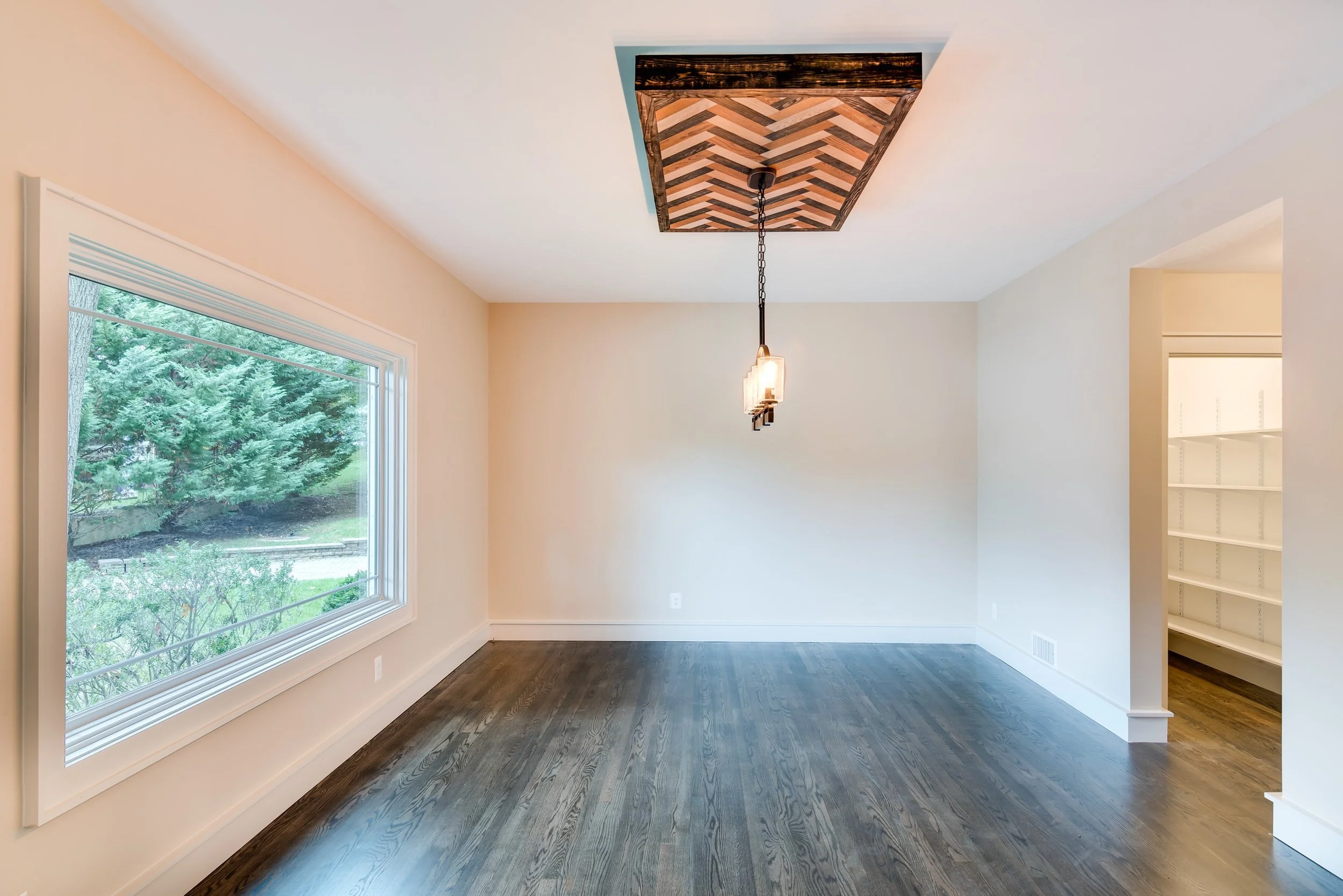 Dining room with hardwood flooring and patterned wood ceiling.jpg