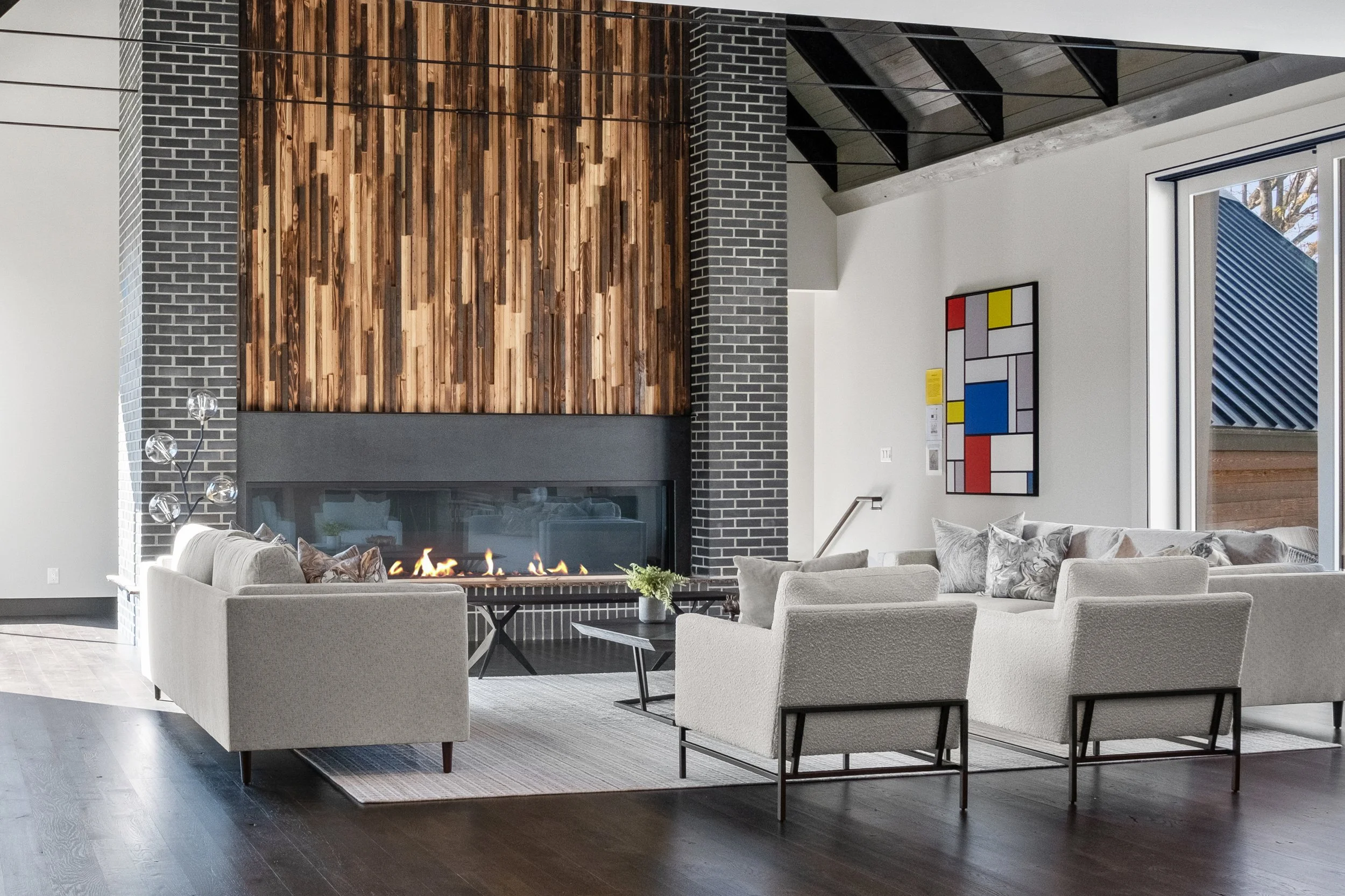 Living room with linear fireplace wood accent wall and gray seating.jpeg