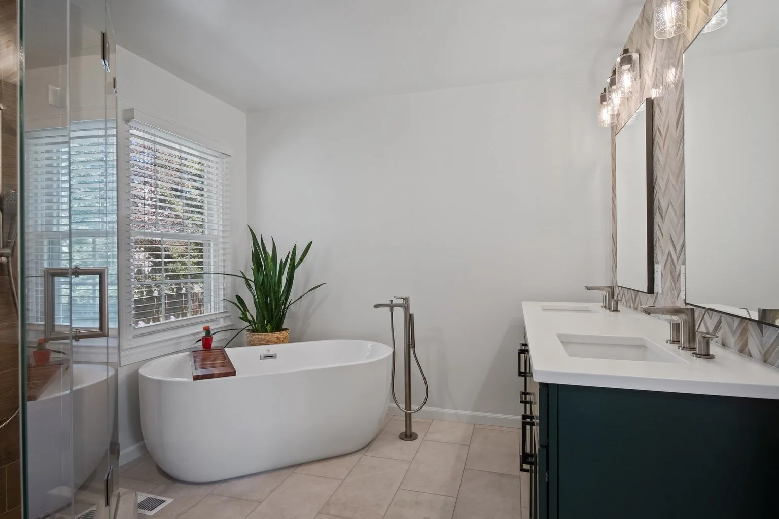 Primary bathroom with a freestanding tub, double vanity and glass shower enclosure.