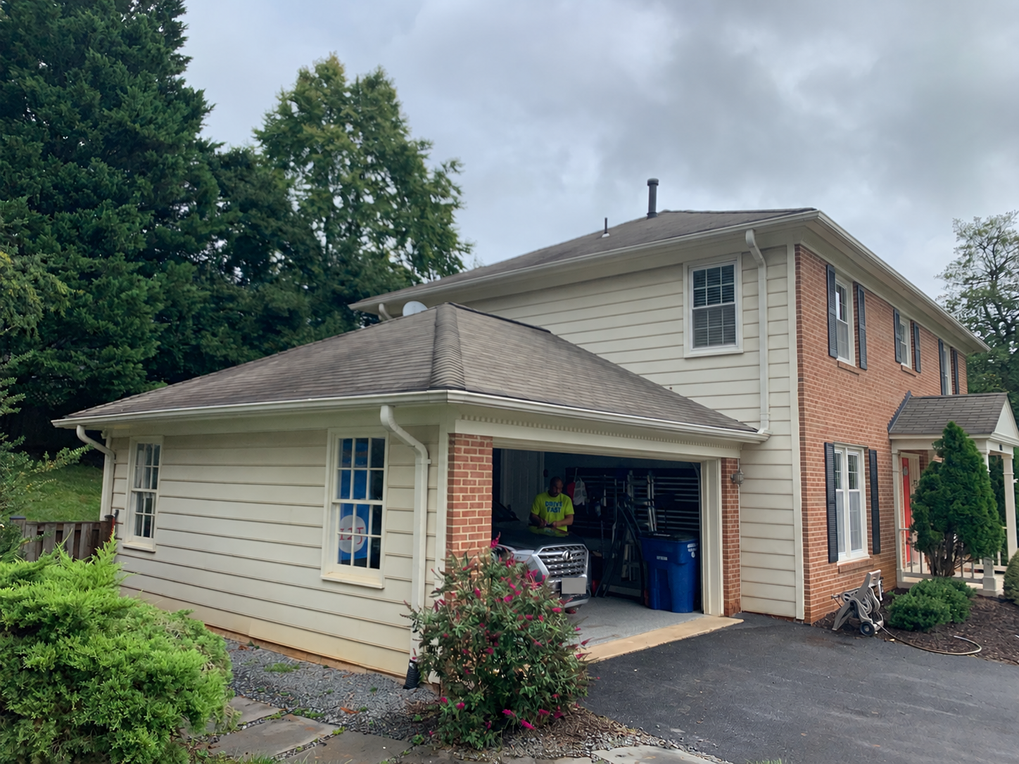 Attached two-car garage with a low hip roof before the primary suite addition in Vienna.