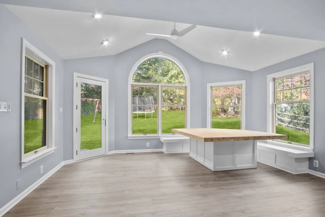 Bright sunroom with vaulted ceiling arched window and built-in benches.jpeg