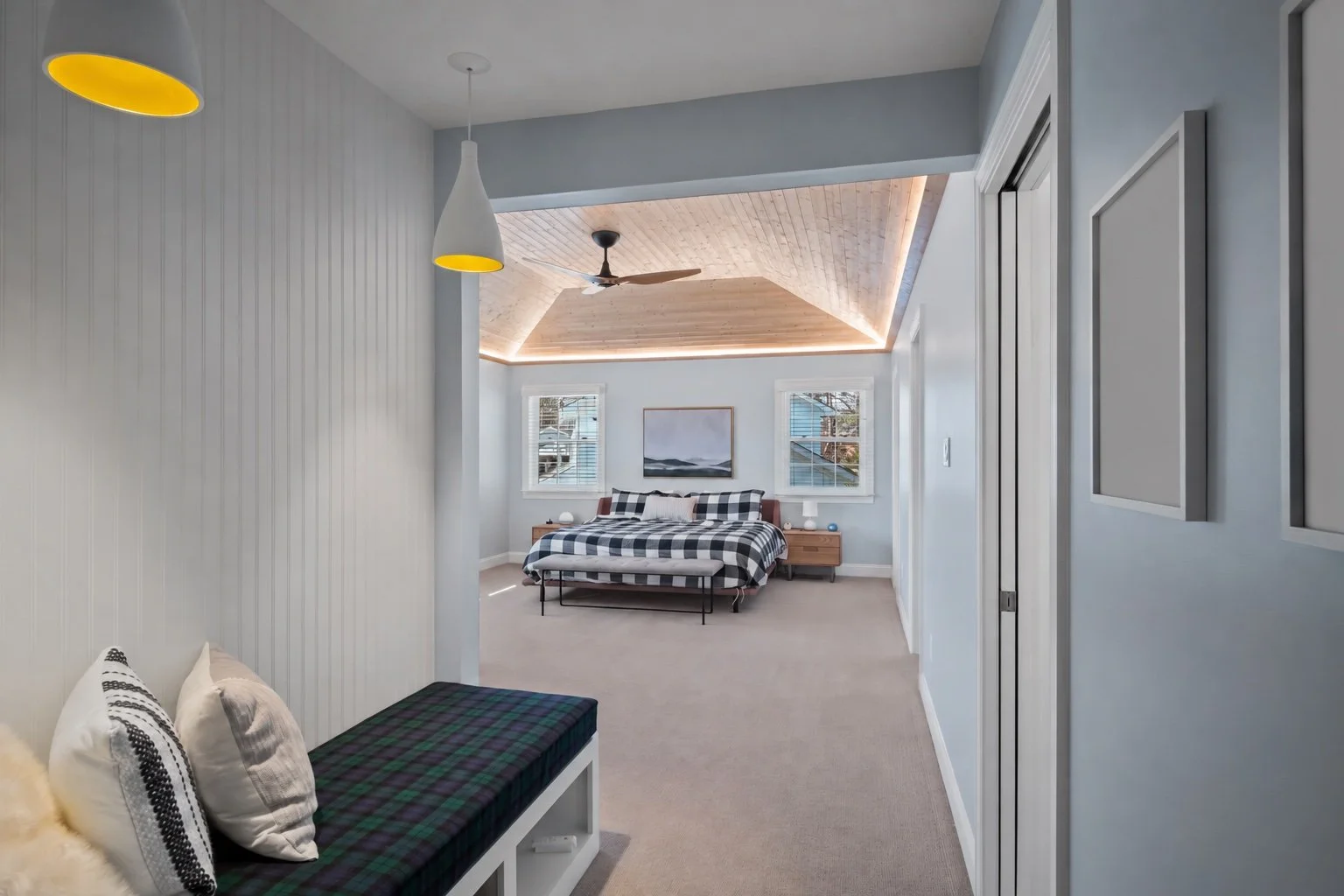 Built-in seating and shelving with pendant lights connecting the existing house to the new primary bedroom.