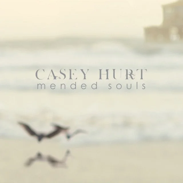 Album cover for Casey Hurt's "Mended Souls" featuring a blurred beach scene with seagulls flying.