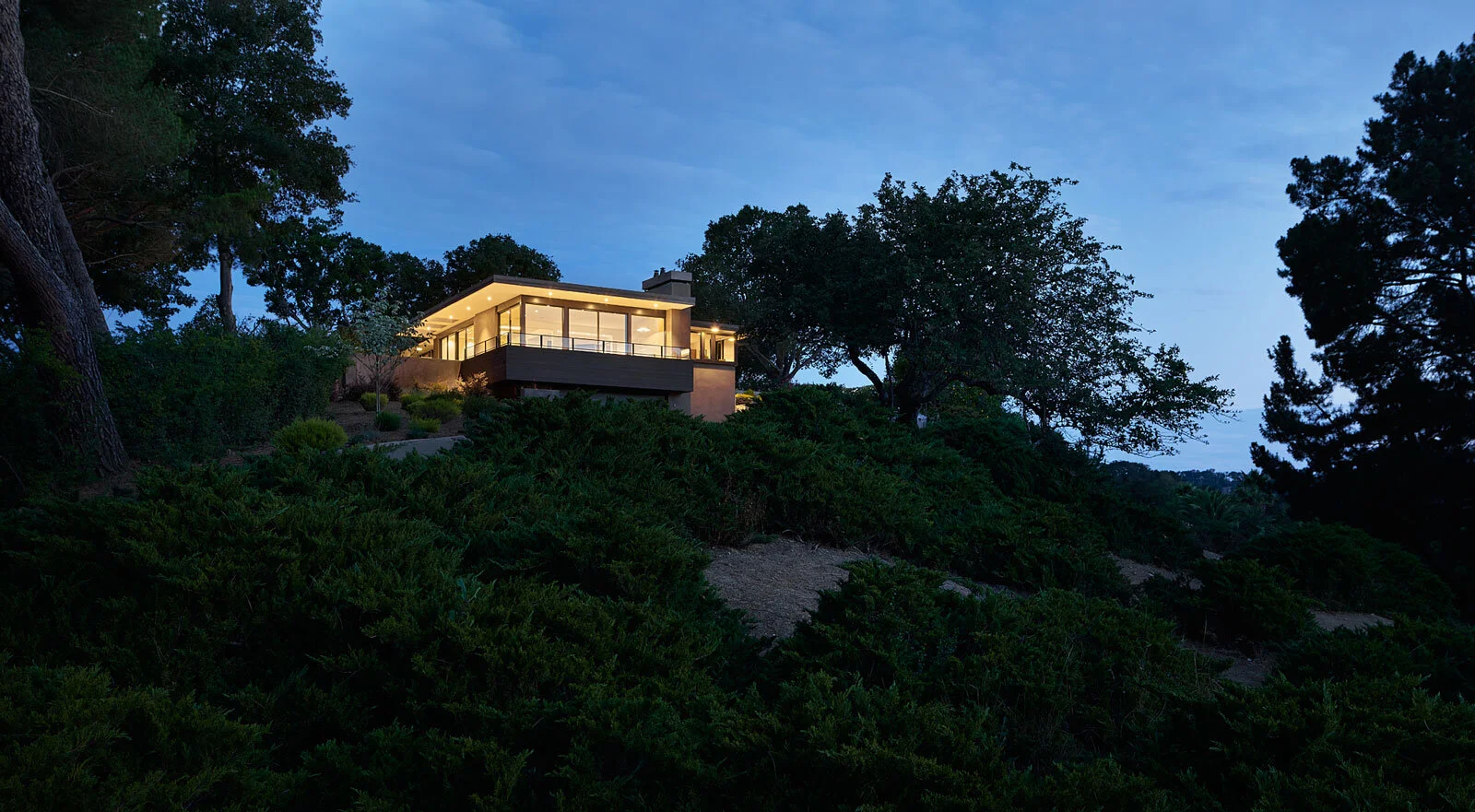 Mid-century modern home renovation with cantilevered balcony and glass railing in Lafayette, California