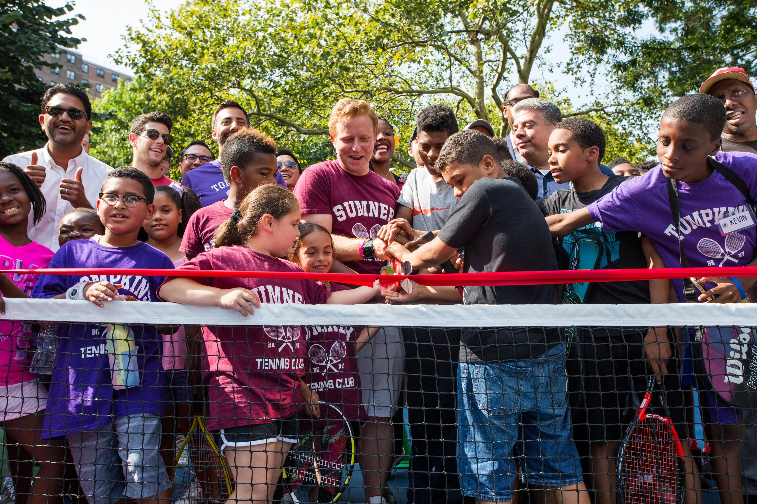 King’s County Tennis Leagues’ students, friends, and family cut the second of two ribbons.