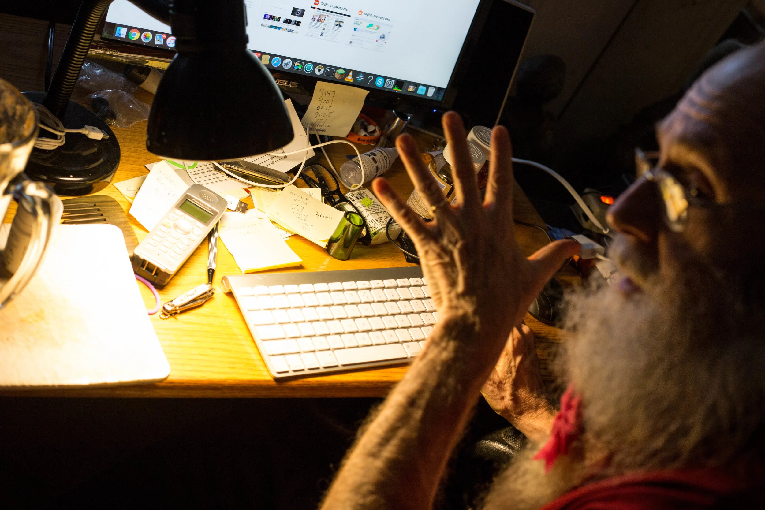 Dennis GRonim and his workplace. On his desk, amongst other items, rests a harmonica, a guitar slide, and a bottle of CBD dummies | Photo by Wes Parnell