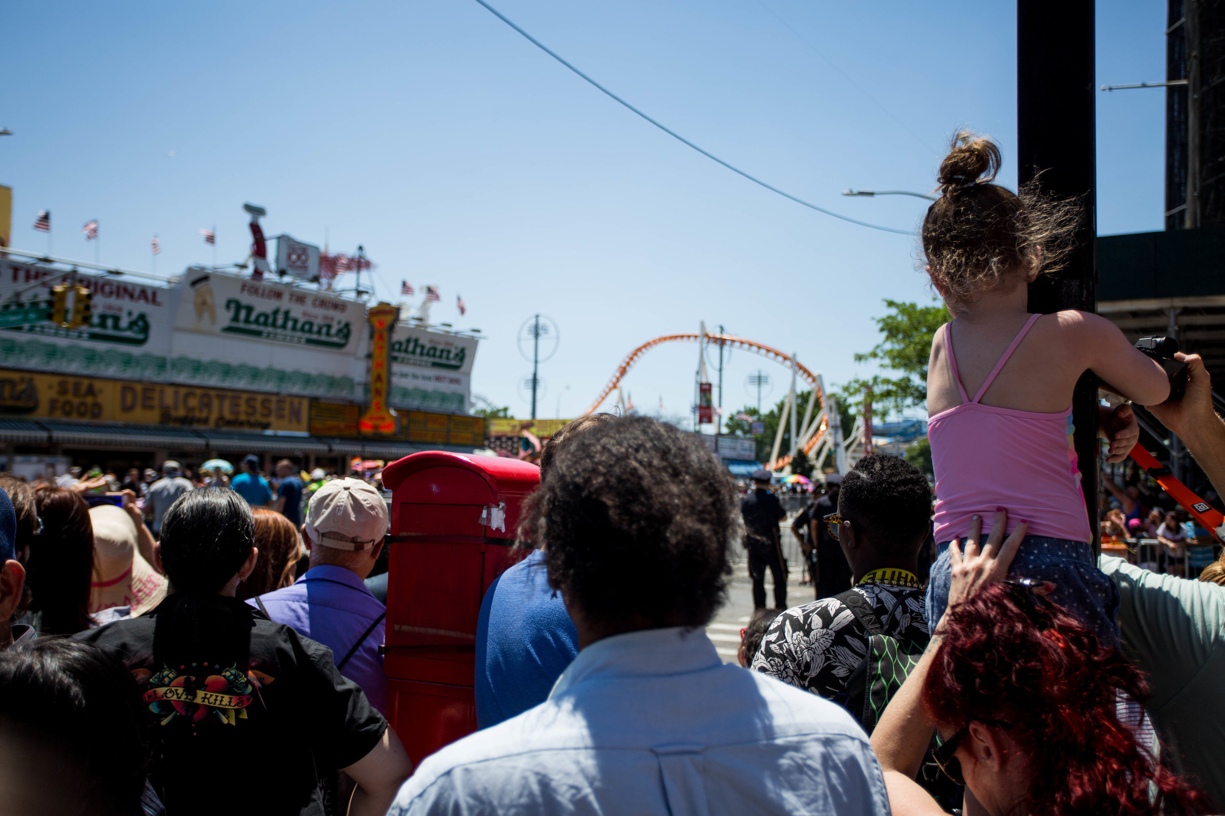  A mother holds her child up in odrder to get a better view over the crowd at Coney Island's 36th anual Mermaid Day Parade, on Saturday June 16, in New York. Photo: Wes Parnell 