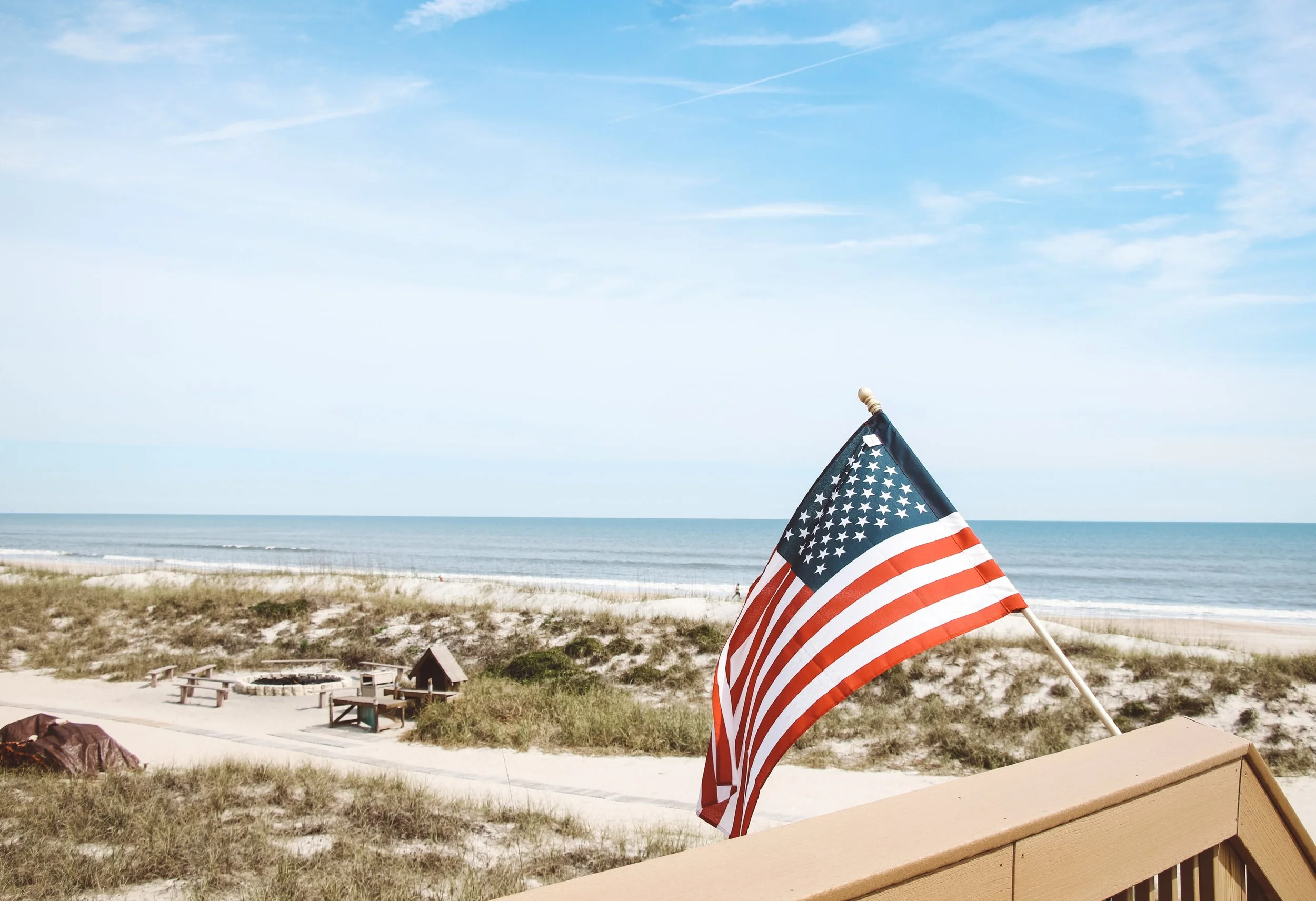 American flag waves over the Atlantic coast in Jacksonville, Florida || Photo by David Masemore on Unsplash .