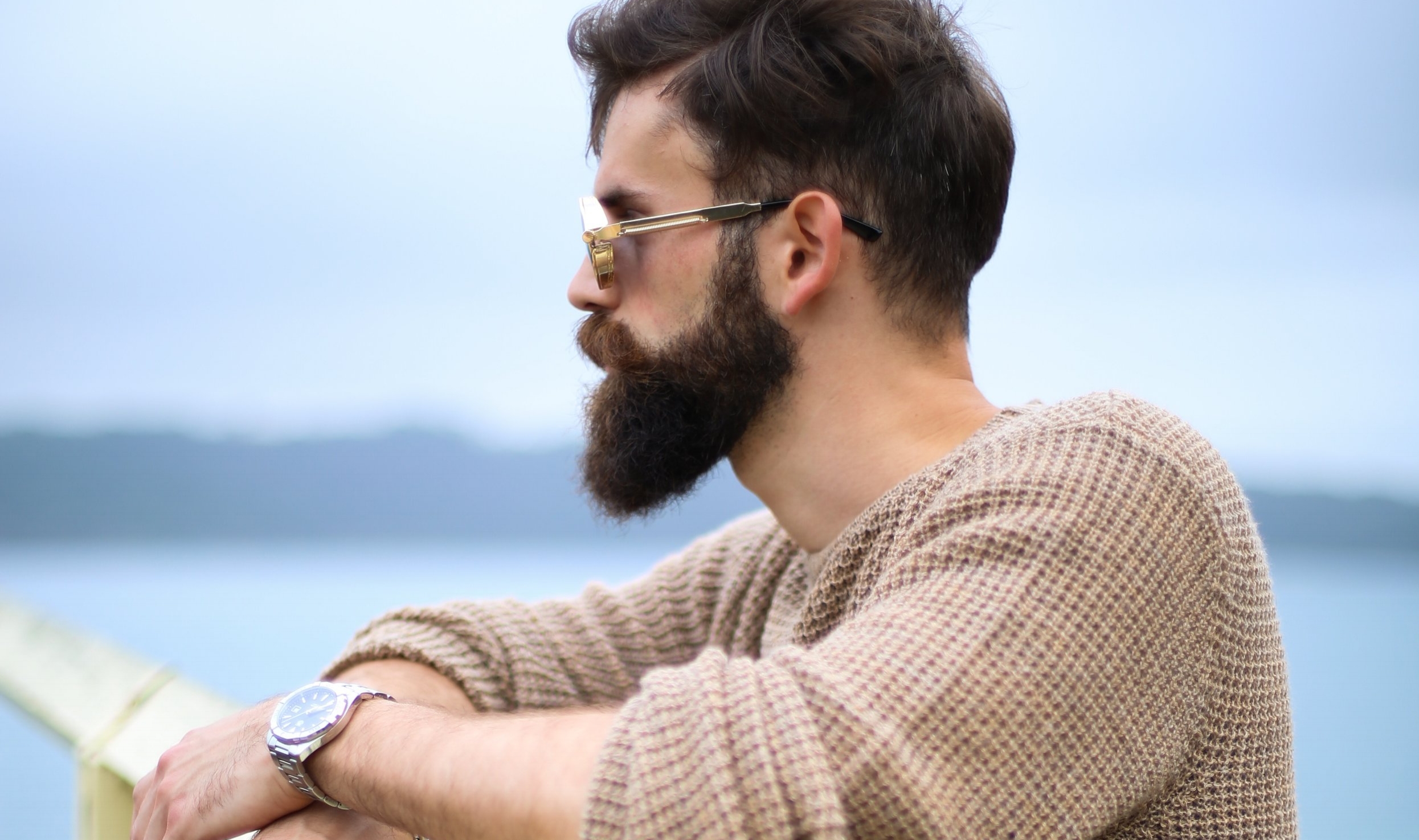 Man wearing brown sweater standing on wooden dock. || Photo by Jonathan Zerger on Unsplash