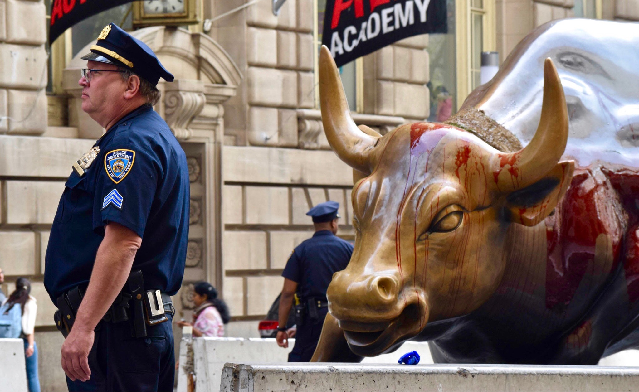 Policemen stand near Charging Bull amidst Extinction Rebellion protesters. || Photo credit to Mitchell Manley