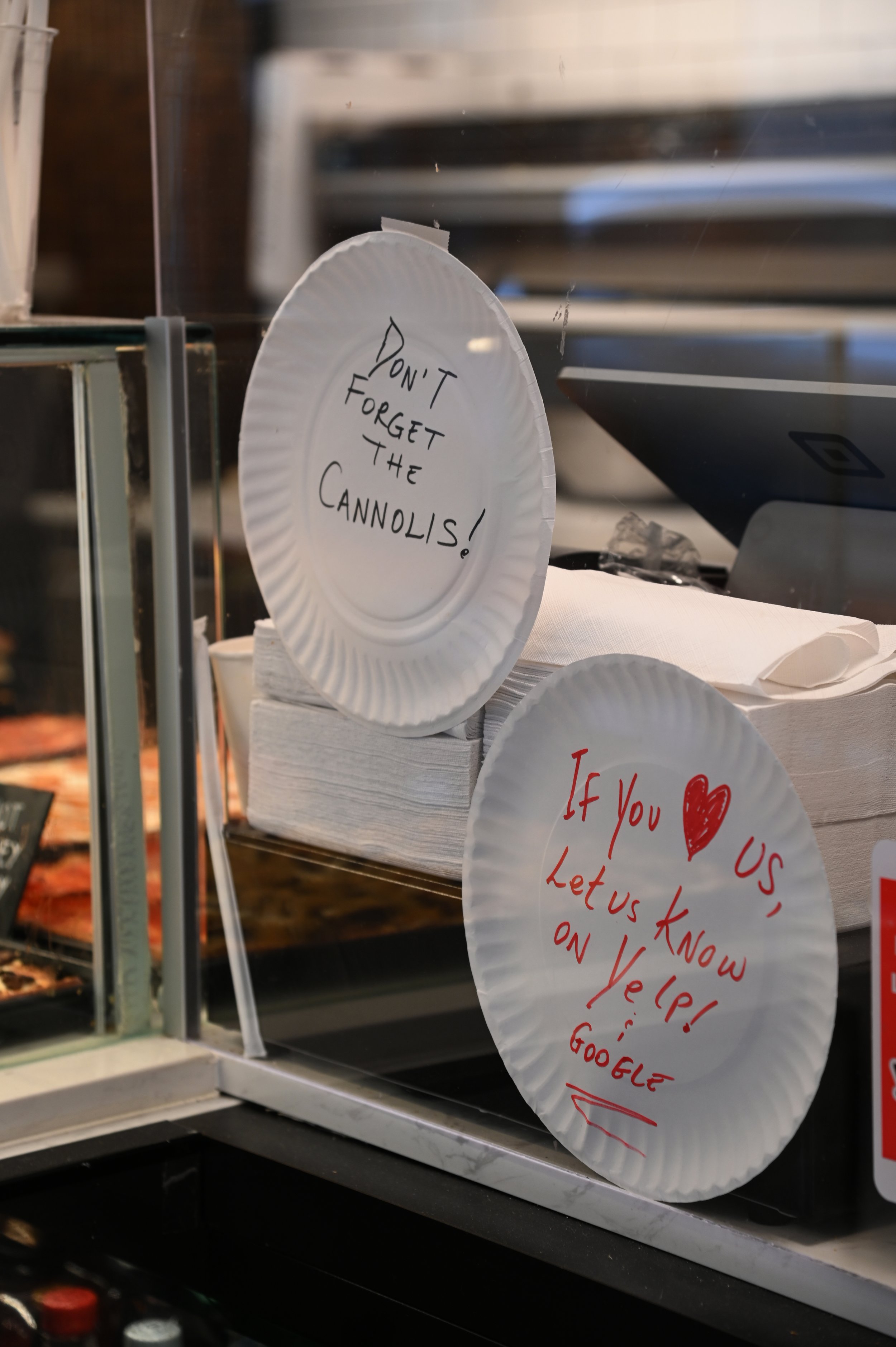  Siena Pizza and Cannoli, the family-owned business made signs from paper plates, reminding customers to grab a cannoli with their pizza and to leave reviews on Yelp on Oct. 12, 2021  in the Financial District of Manhattan, NY, (Alyse Messmer/The Kin