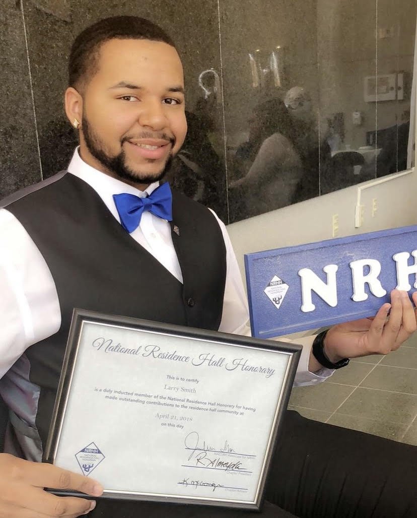  ​​Larry Malcolm Smith holds an award for “National Residence Hall Honorary” which he received on April 21, 2018, from SUNY College Old Westbury for “having made outstanding contributions to the residence hall community.” | Photo courtesy of Smith. 