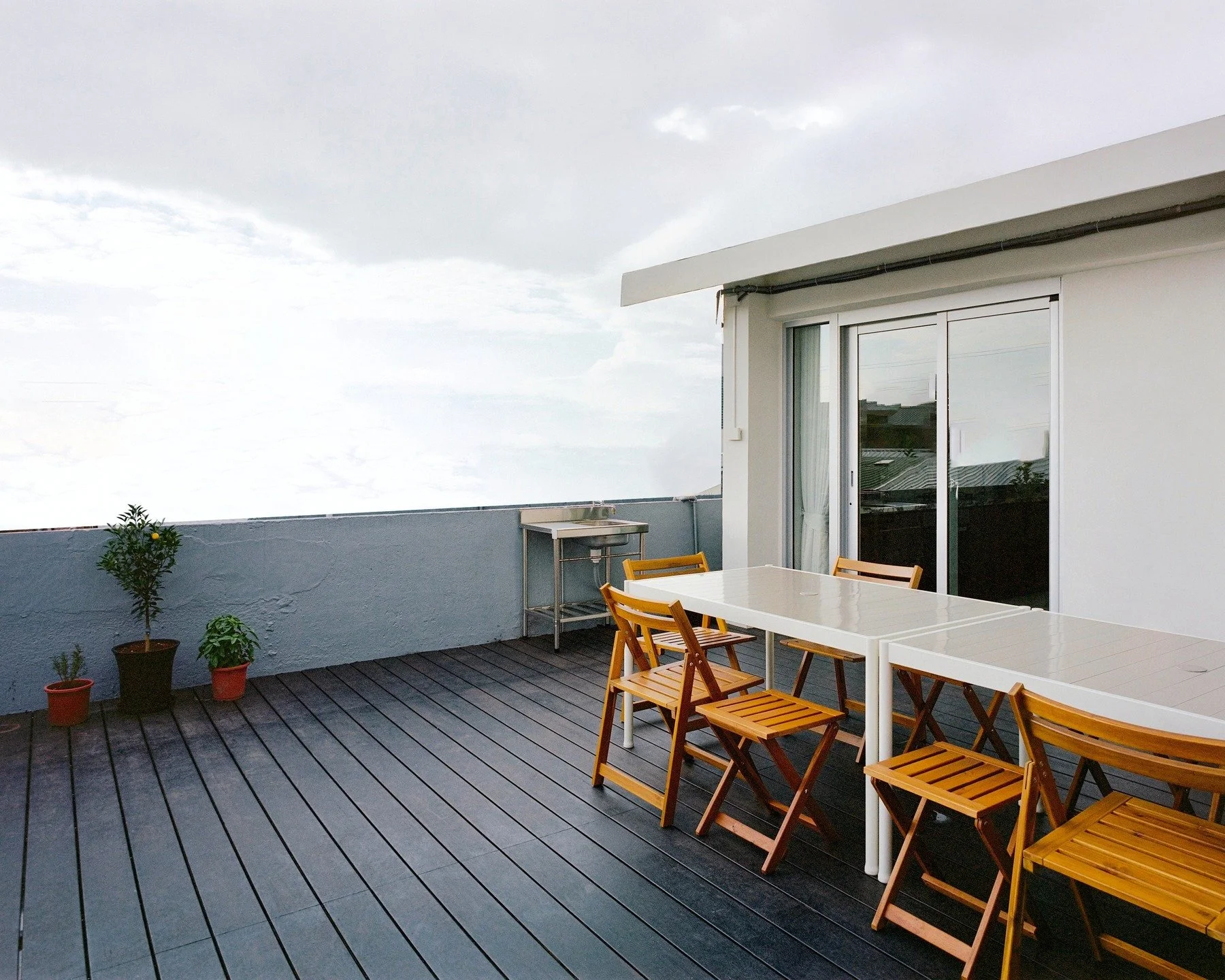 材質選品｜將舒適延伸至戶外：竹鹿 高密度竹炭木

住在老公寓頂層的人，怎麼樣可以擁有一個美好的都市花園，又同時降低夏天炎熱的室內溫度？

都市裡，頂樓露台是珍貴的喘息空間。然而，台灣許多老舊公寓頂樓缺乏隔熱層，曝曬整天的混凝土地坪極易蓄熱，導致頂層公寓的生活空間在夏季幾乎難以忍受，需要耗費很多的冷氣電力來維持舒適的室內溫度。

本住宅案也是個頂層老公寓翻新，設計方式不僅創造了一座能欣賞城市天際線的屋頂花園，也從建築構造的本質，解決屋頂花園下方室內高溫的問題。

解決方案藏在屋頂地坪的工法與材質選