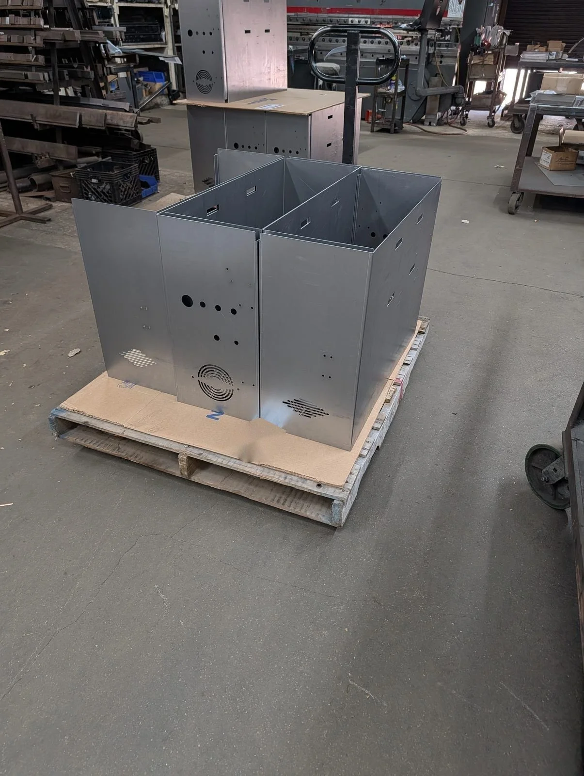 Formed steel enclosures with punched vent patterns on a pallet