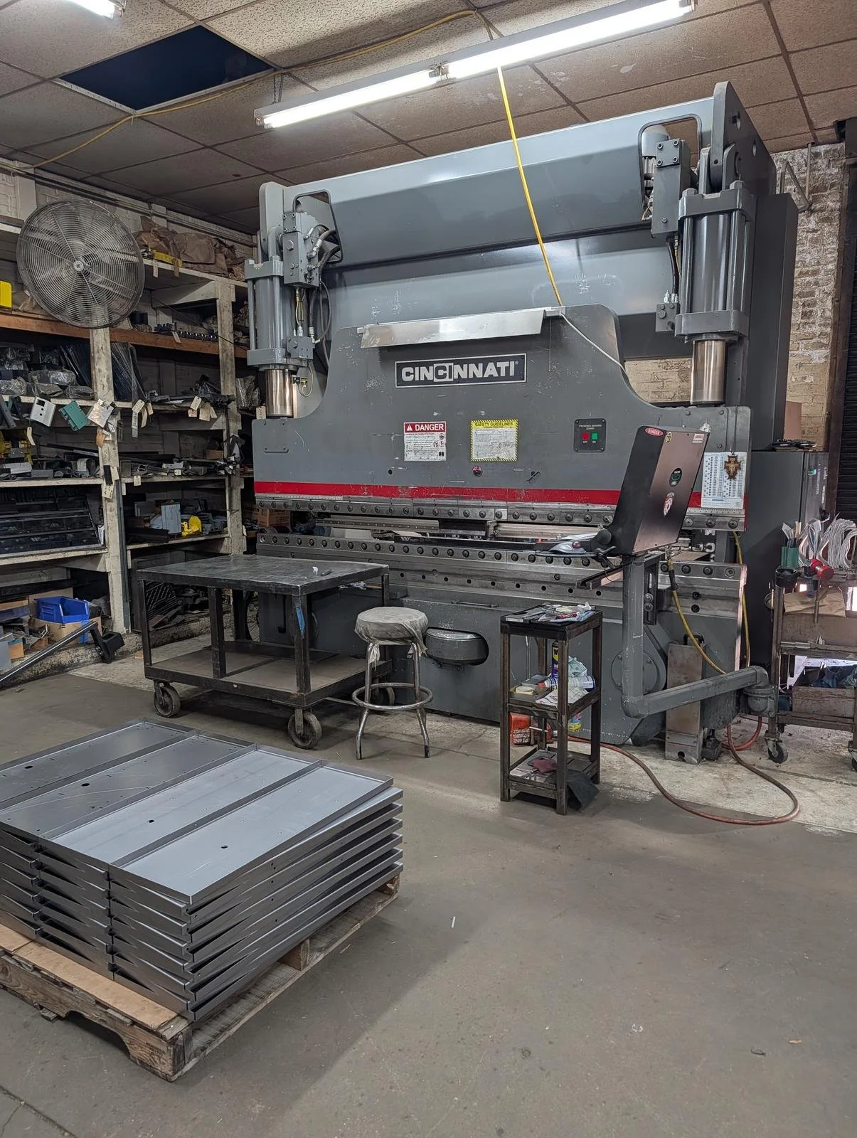 CNC press brake in the shop with a pallet of formed steel panels in front