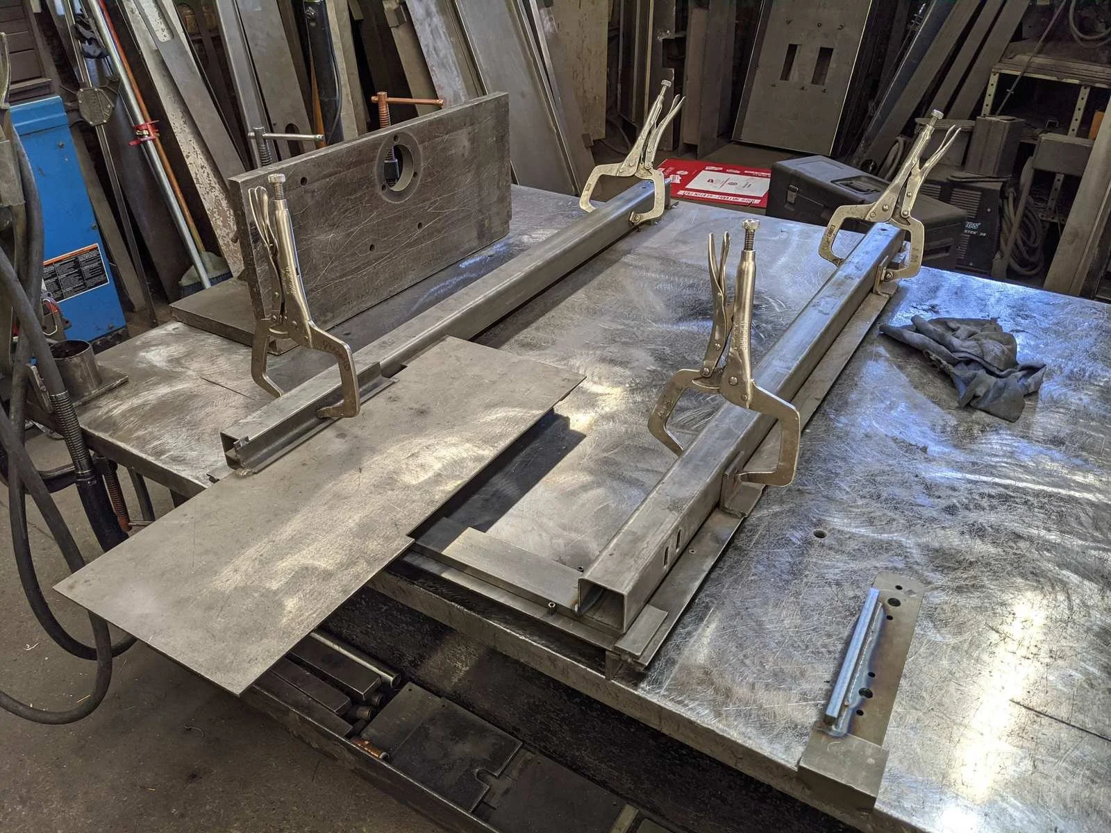 Steel tube frame clamped in a welding fixture on a steel weld table
