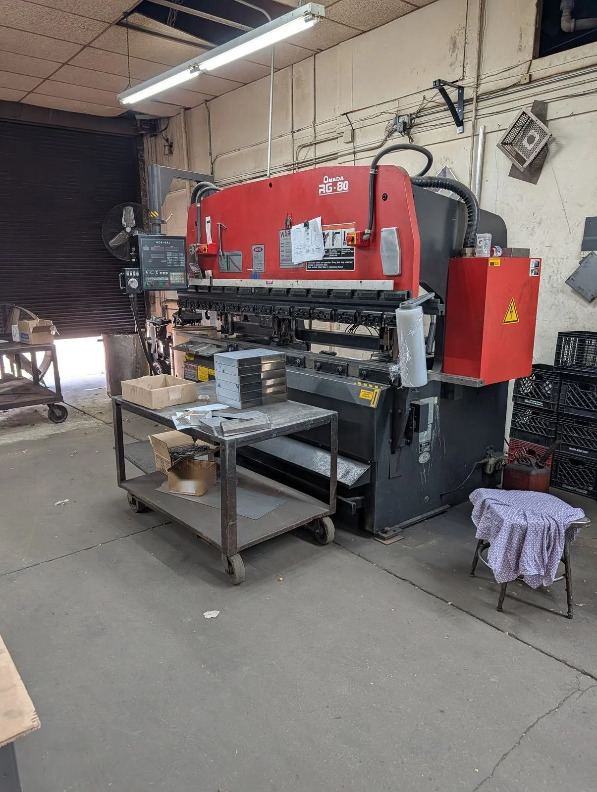 CNC press brake with a cart of formed sheet metal parts