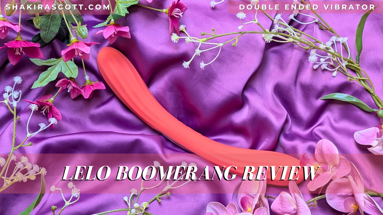LELO Boomerang double ended vibrator in coral red surrounded by flowers