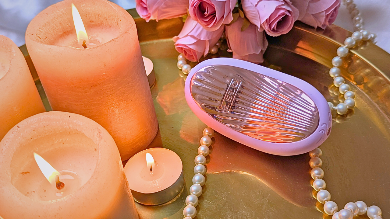 LELO SONA 3 Cruise clitoral vibrator on a gold tray with flowers, candles and pearls
