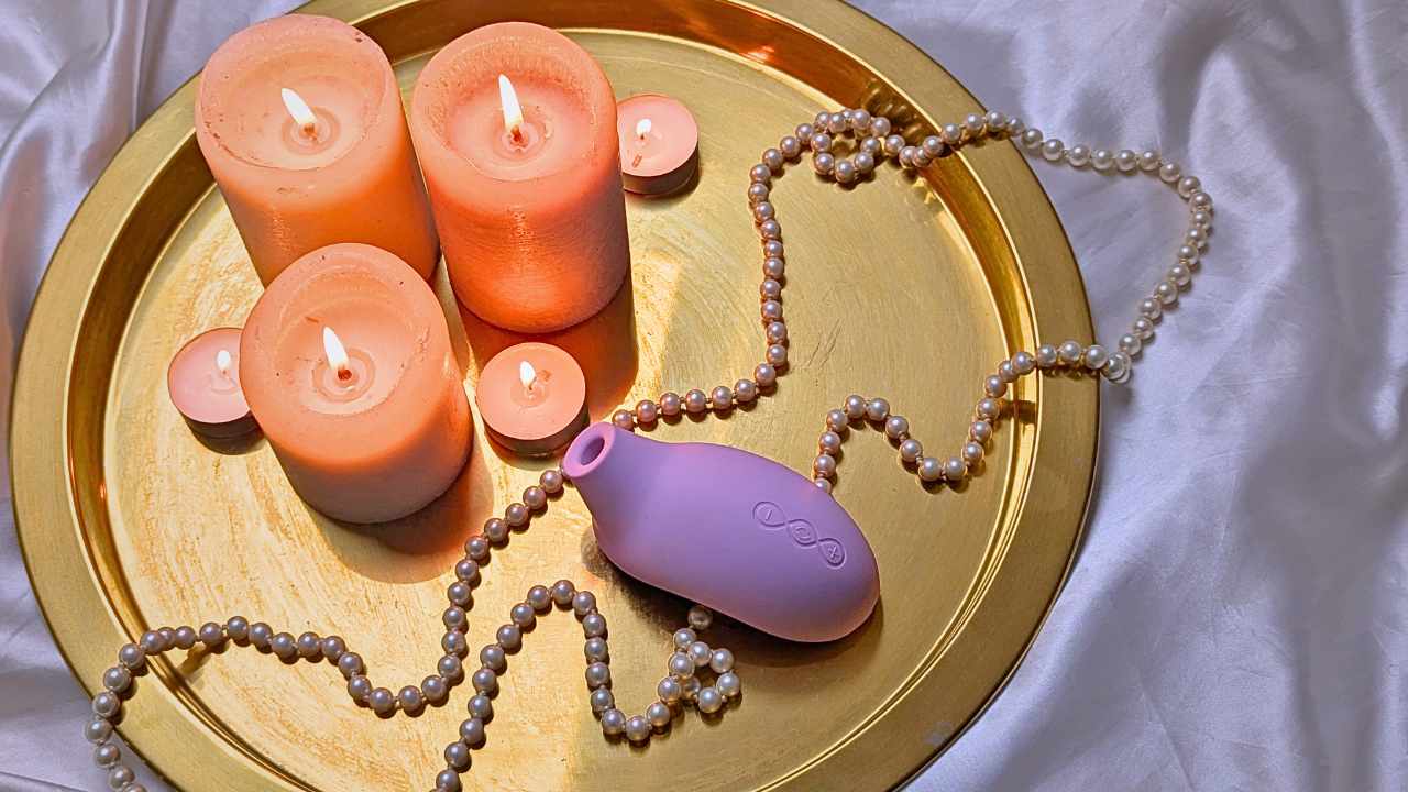LELO SONA 3 Cruise clitoral stimulator on a gold tray with pearls and candles