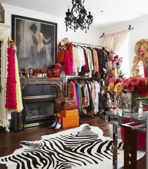 a-colorful-walk-in-closet-with-open-storage-units-a-fireplace-a-zebra-print-rug-a-black-chandelier-and-a-pretty-glass-vanity.jpg