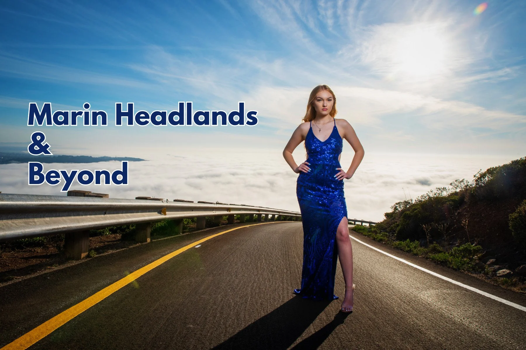 Woman in blue dress standing on a road with guardrails, overlooking clouds and a blue sky, text reads 'Marin Headlands & Beyond.'