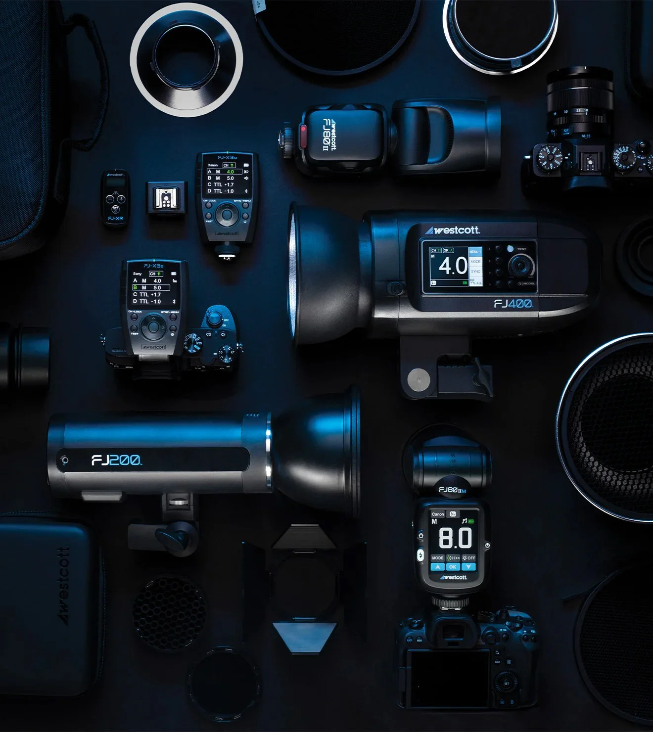 Photography equipment including cameras, lenses, flashes, and accessories on a dark background. Brands and models include Westcott and a Nikon camera. The layout is organized for display, showcasing a variety of gear.
