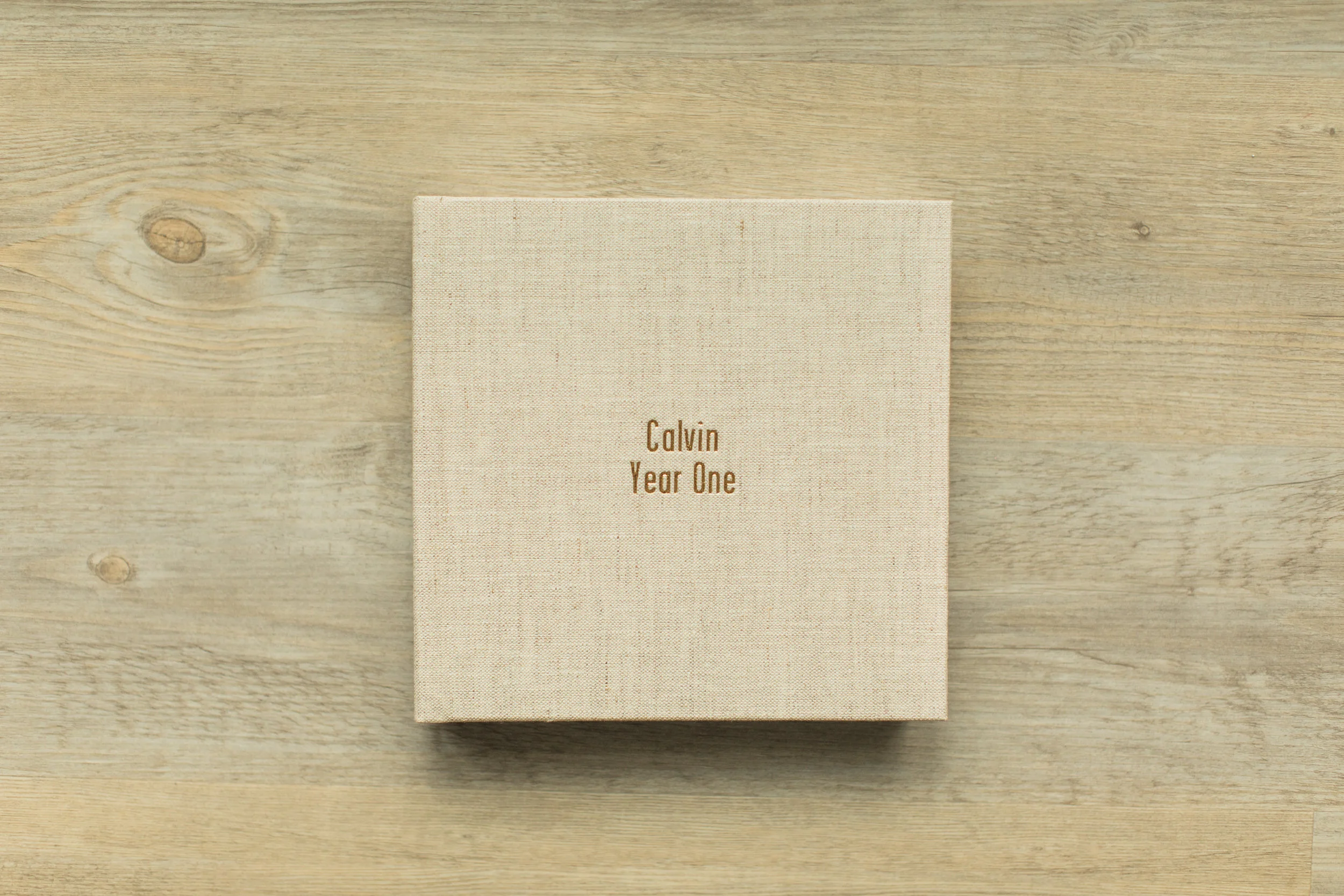 A baby photo album sits on a wooden table.