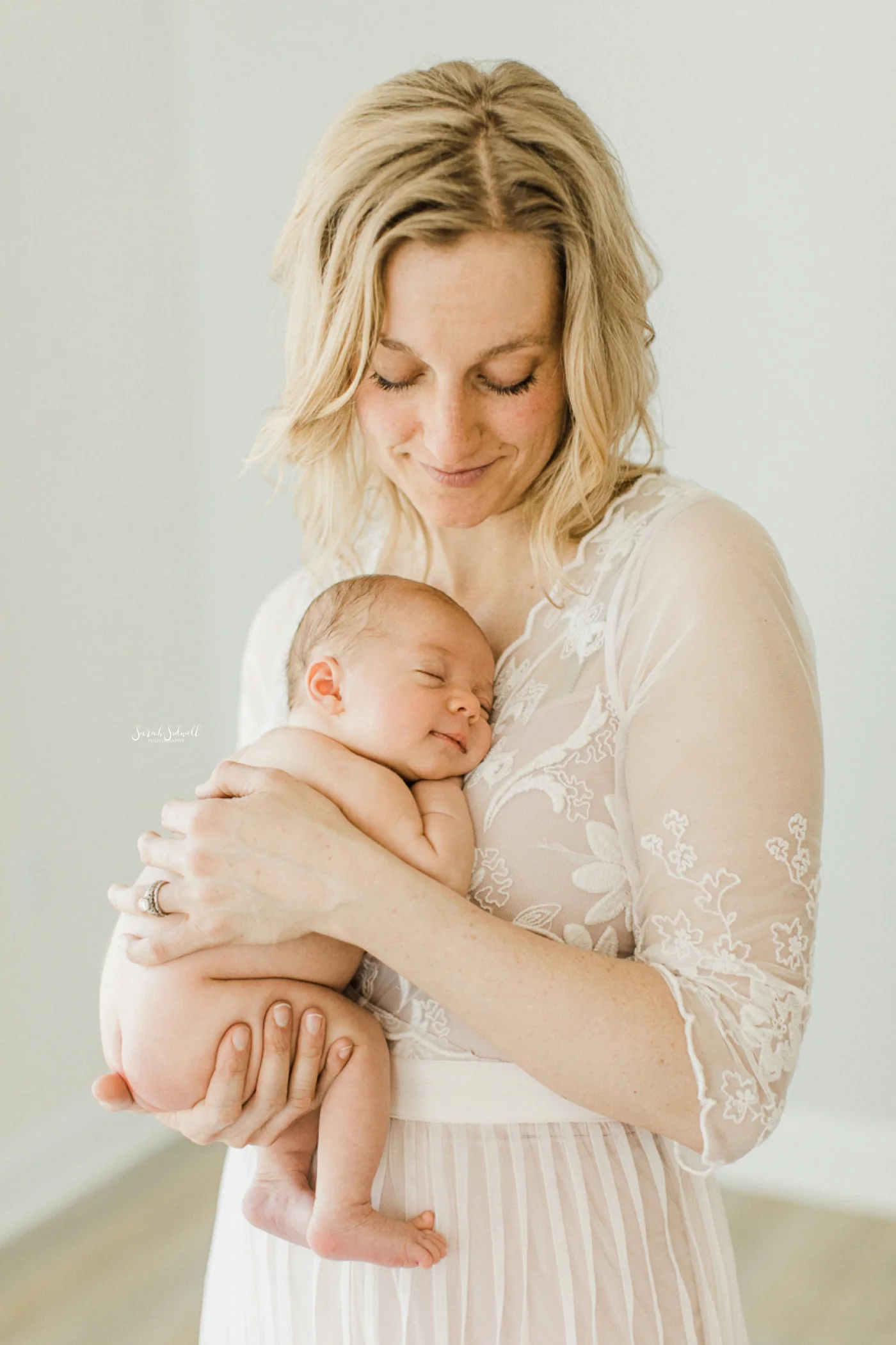 A mother holds her newborn close to her chest.
