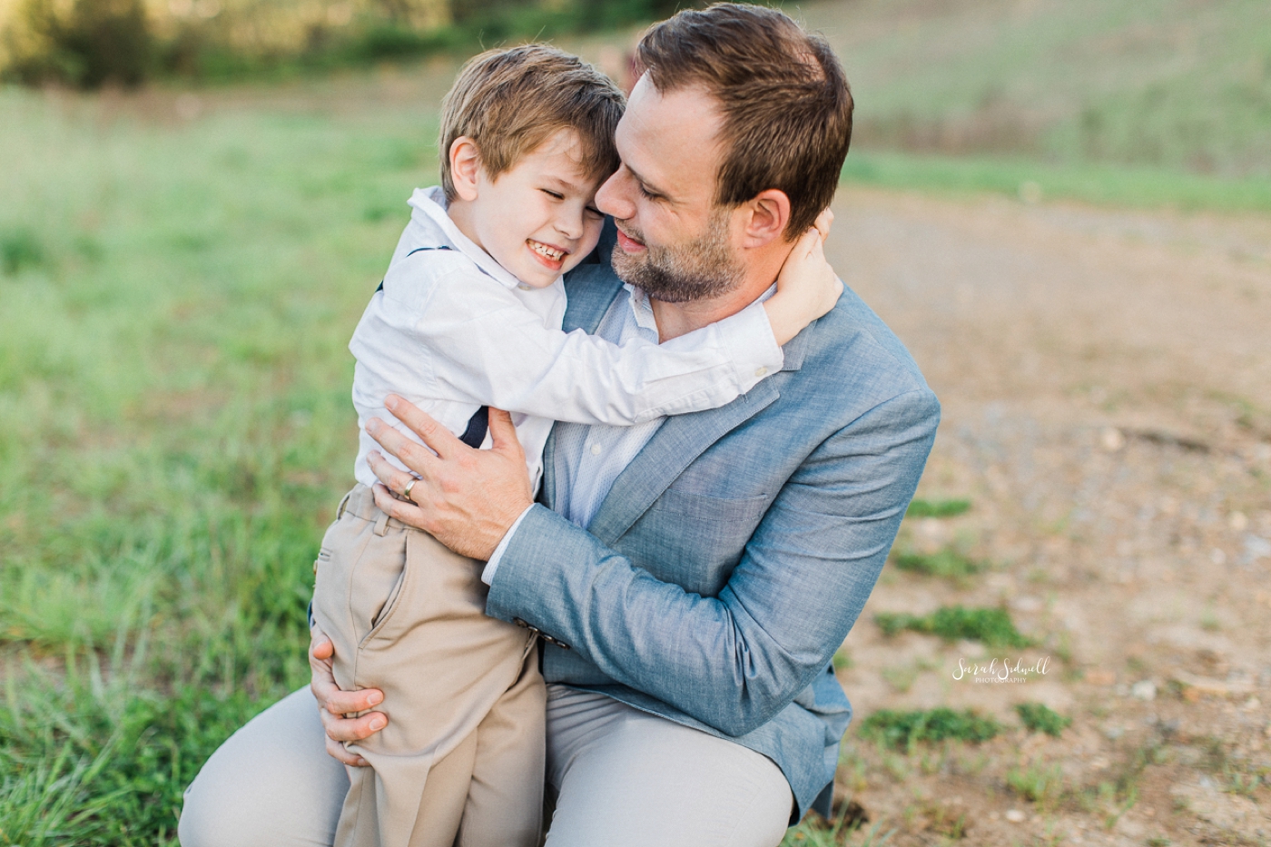 A father holds his son on his lap.