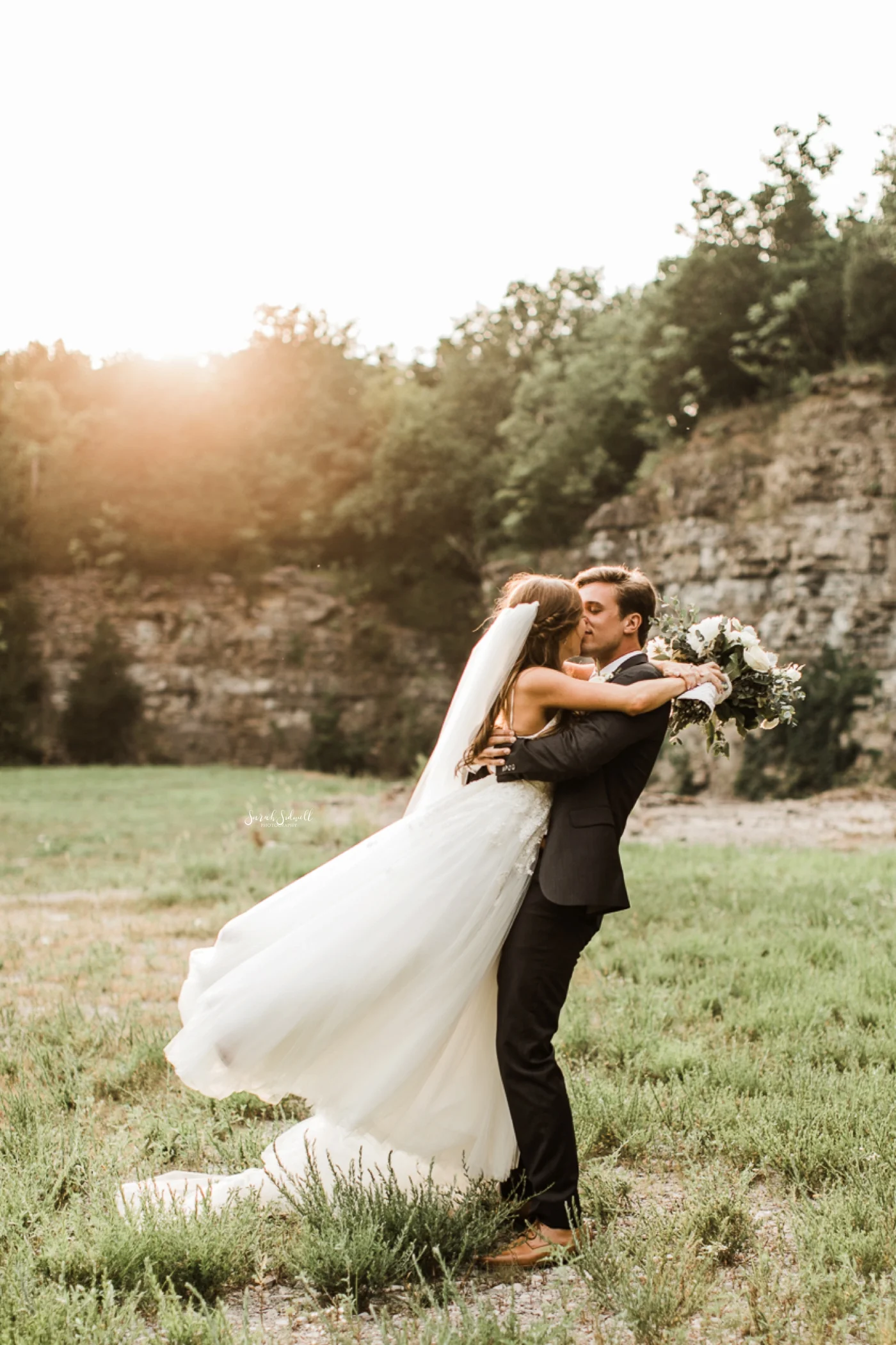 A bride jumps into the arms of her groom.