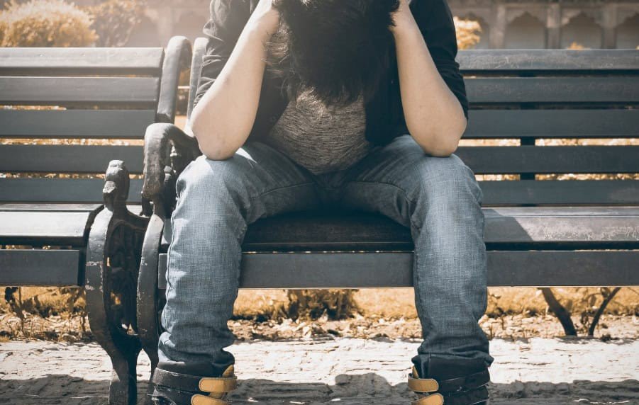 Visar en uppgiven ungdom på en parkbänk