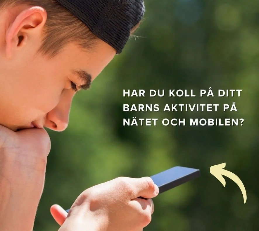 En fundersam pojke som håller en mobil i sin hand