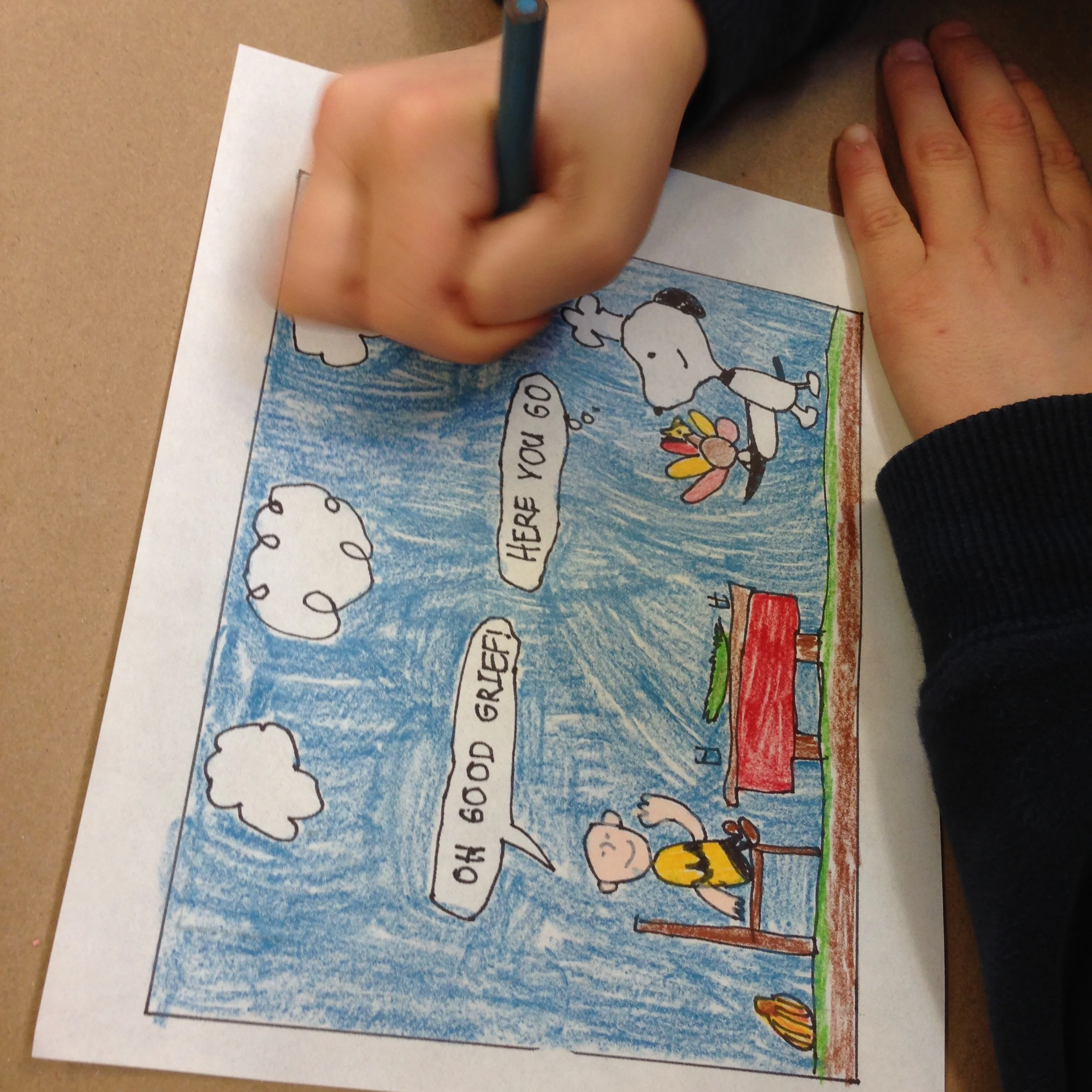 Aaron adding the finishing touches of blue to his Peanuts cartoon. 
