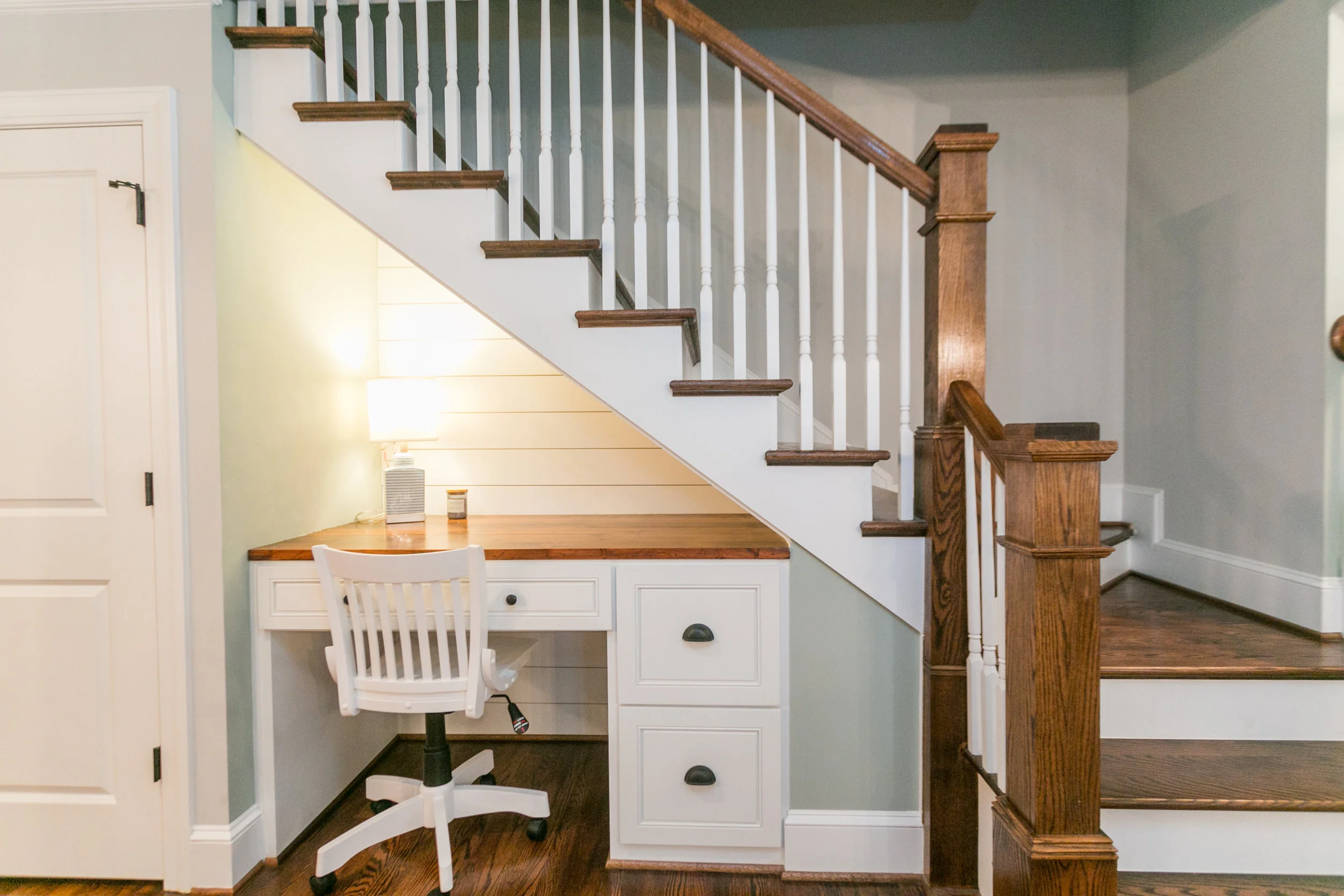 The back of the desk wall has shiplap to add texture under the stairs with the stained desk top.