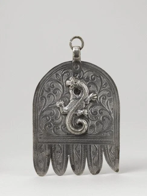 Pendant. Maghreb, Morocco, Casablanca, early 20th CE. Made by Jewish artisans. Outfit of both Jewish and Muslim women. Talisman against the evil eye. The salamander is a positive symbol in Jewish tradition. Silver, engraved and chiseled, 12,2 x 8,2 x 1,2 cm, 79 g. Inv. 74.1965.2.2. Photo: Michel Urtado / Thierry Ollivier. Location: Musee du Quai Branly, Paris, France Photo Credit: © musée du quai Branly - Jacques Chirac, Dist. RMN-Grand Palais / Art Resource, NY Image Reference: ART522175