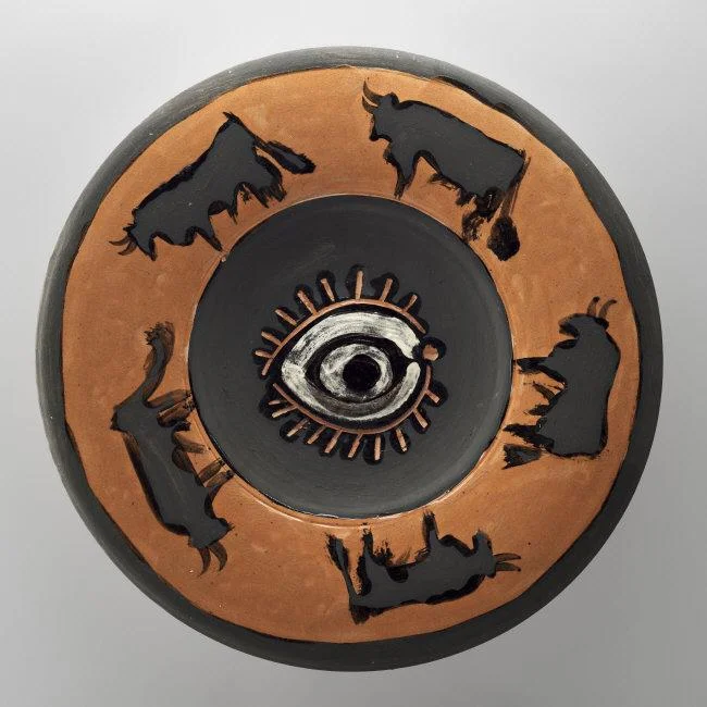  Pablo Picasso, (1881-1973) © ARS, NY Spanish Dish Decorated with an Eye and Bulls . 1957. Red terracotta, incised, partially covered, painted with clay engobe, ceramic, diam. 40 cm. MP3741. Photo: Mathieu Rabeau. Location: Musee Picasso, Paris, France Photo Credit: © RMN-Grand Palais / Art Resource, NY Image Reference: ART523442