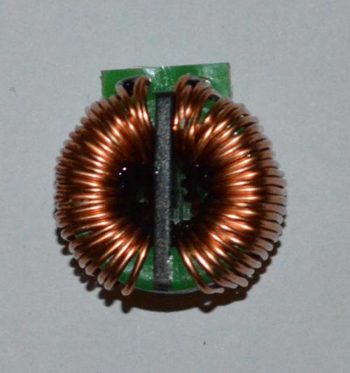Filter choke consisting of two separate inductors wound on the same magnetic core. The black plastic piece in the middle separates the two inductors. Two wires are used in parallel, in order to increase the current carrying capability.