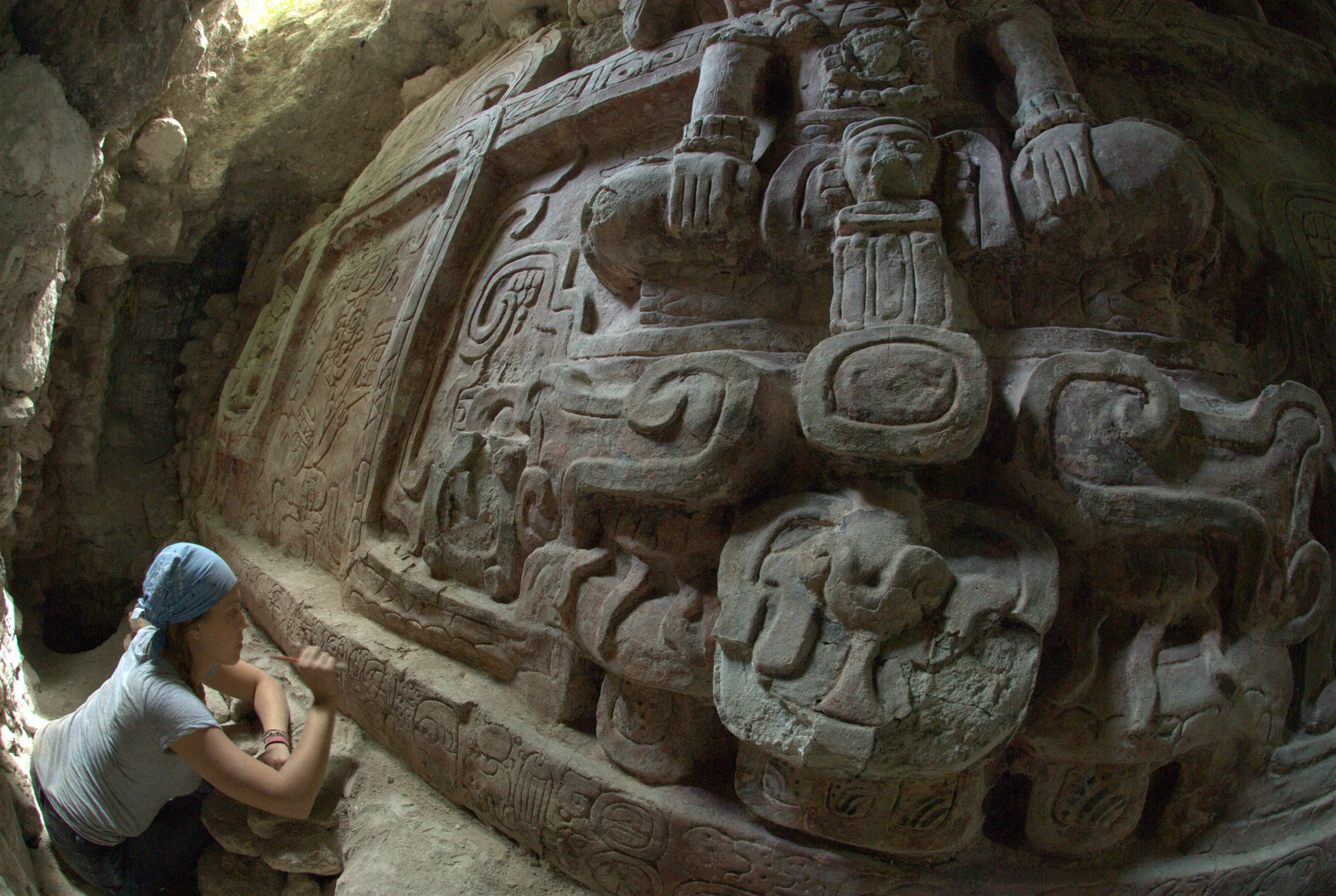 Archaeologist Anya Shetler cleans an inscription below an ancient stucco frieze recently unearthed in the buried Maya city of Holmul in the Peten region of Guatemala. (Photo: cbsnews.com)