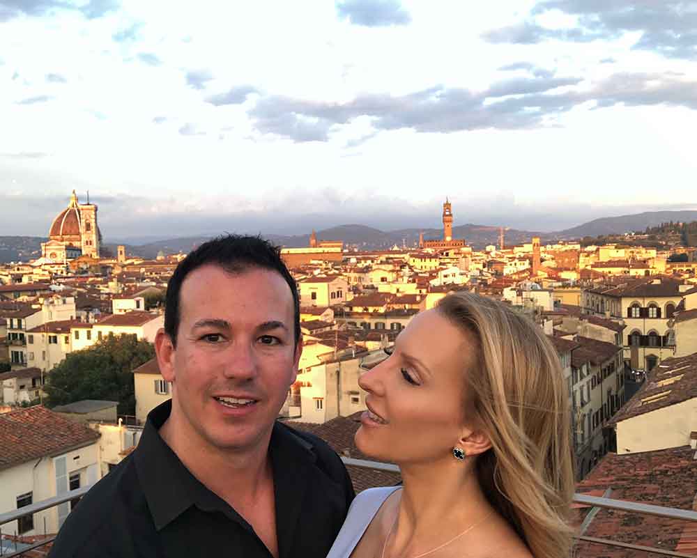 Romantic couple panoramic sunset views Se’ Sto on Arno Florence Rooftop Bar.