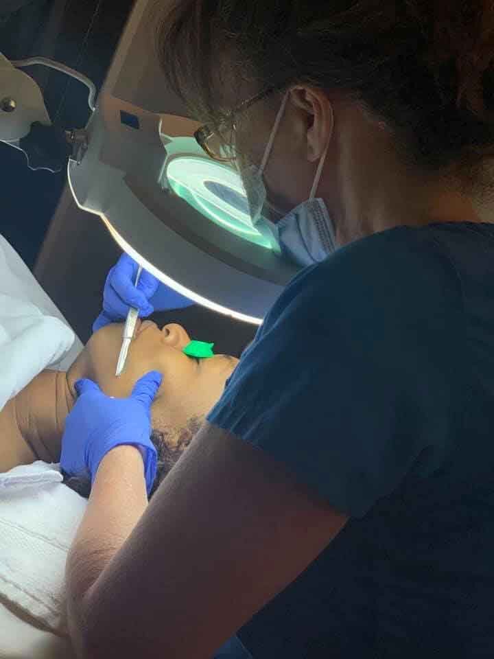 Nurse practitioner at work Dermaplaning client for glowing skin