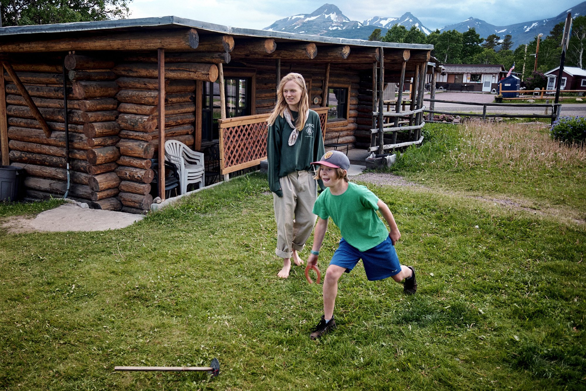  Noisy and Avon play rubber horseshoes on a rainy afternoon at Looking Glass, our basecamp while piecing our way through the park. | East Glacier, MT 6/29/22 Day 8 