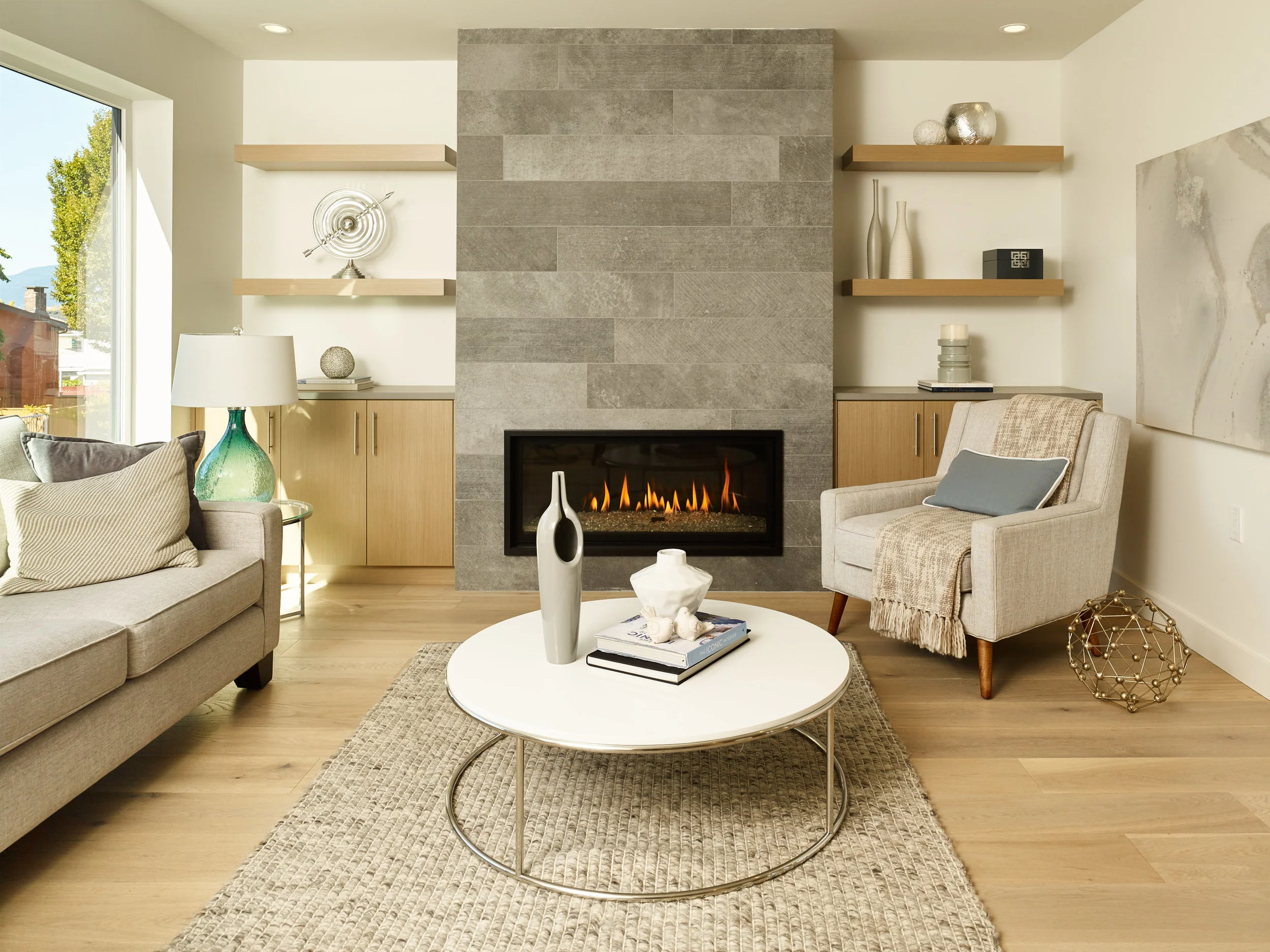 The kitchen's brick-patterned backsplash is mirrored in this fireplace surround. This great room handles elegant, minimalist furniture and decorations while still feeling warm and comfortable. Modern living without being pretentious.