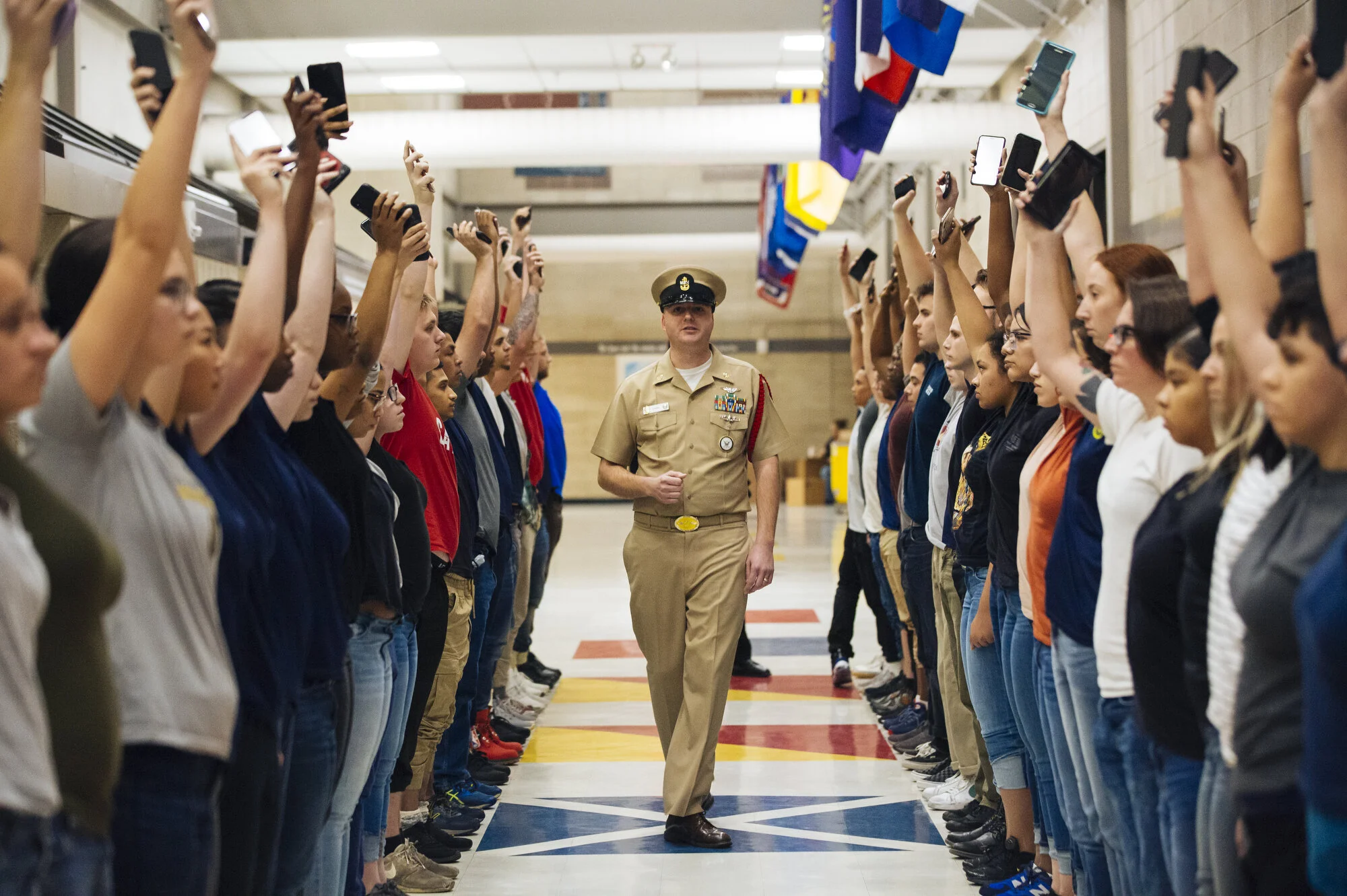  Recruits hold up their phones at Naval Station Great Lakes on Wednesday Feb. 12, 2020 in North Chicago, Ill. Recruits make one call to one family member or friend to let them know they have arrived and then they turn in their phones. CREDIT: Taylor 