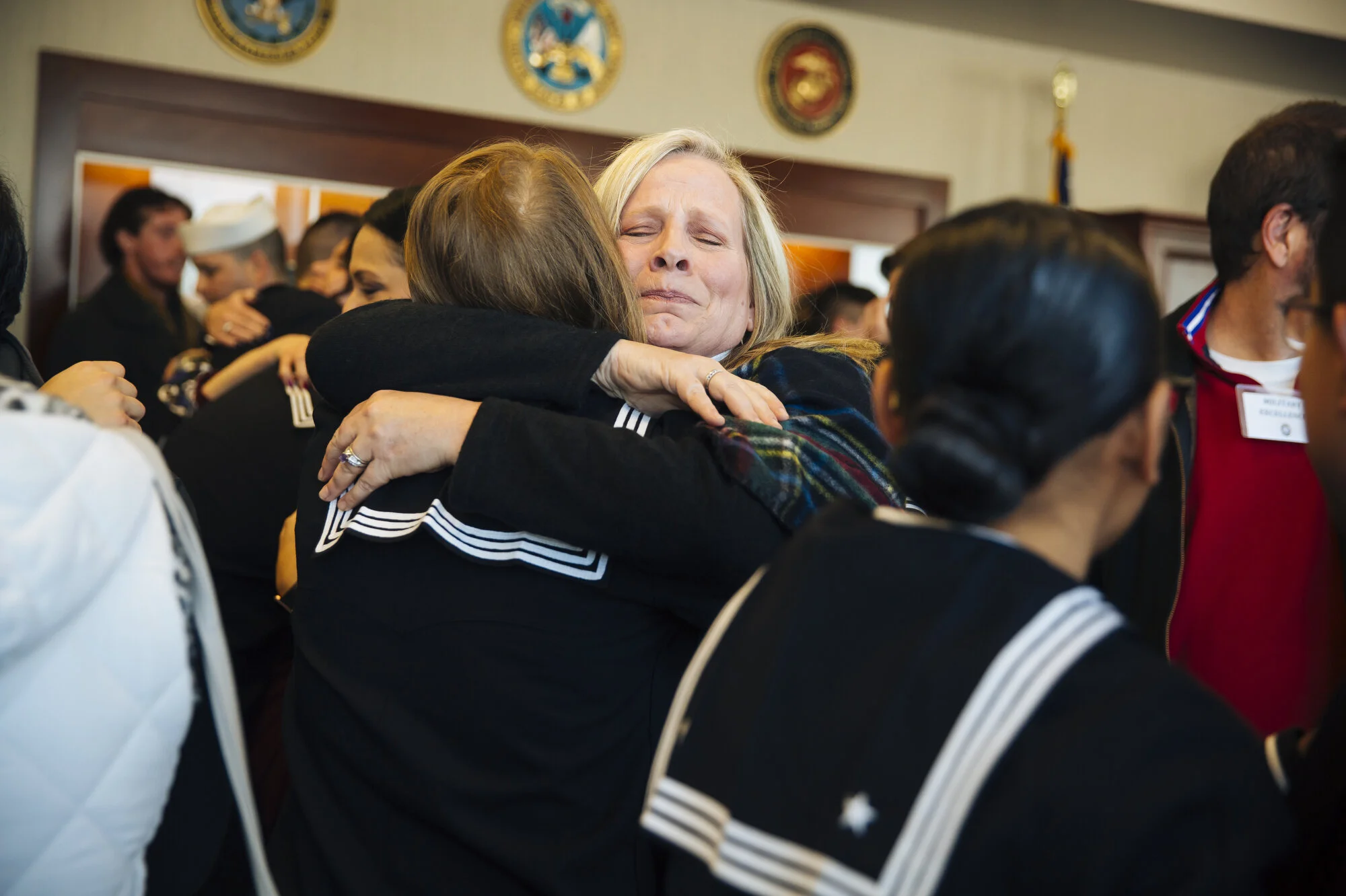  Kim Rampey of Broken Arrow, Okla. (center) hugs Sayre Whiteley after gradation at Naval Station Great Lakes on Friday Feb. 14, 2020 in North Chicago, Ill. Whiteley won the Navy Club of the United States Military Excellence award. CREDIT: Taylor Glas